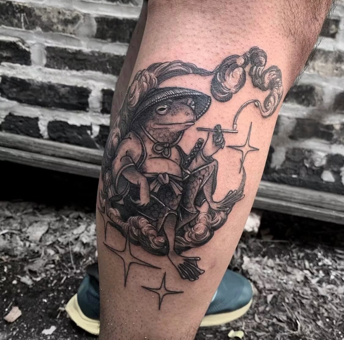 Frog magician black and grey tattoo on the thigh by Javier Rivera
