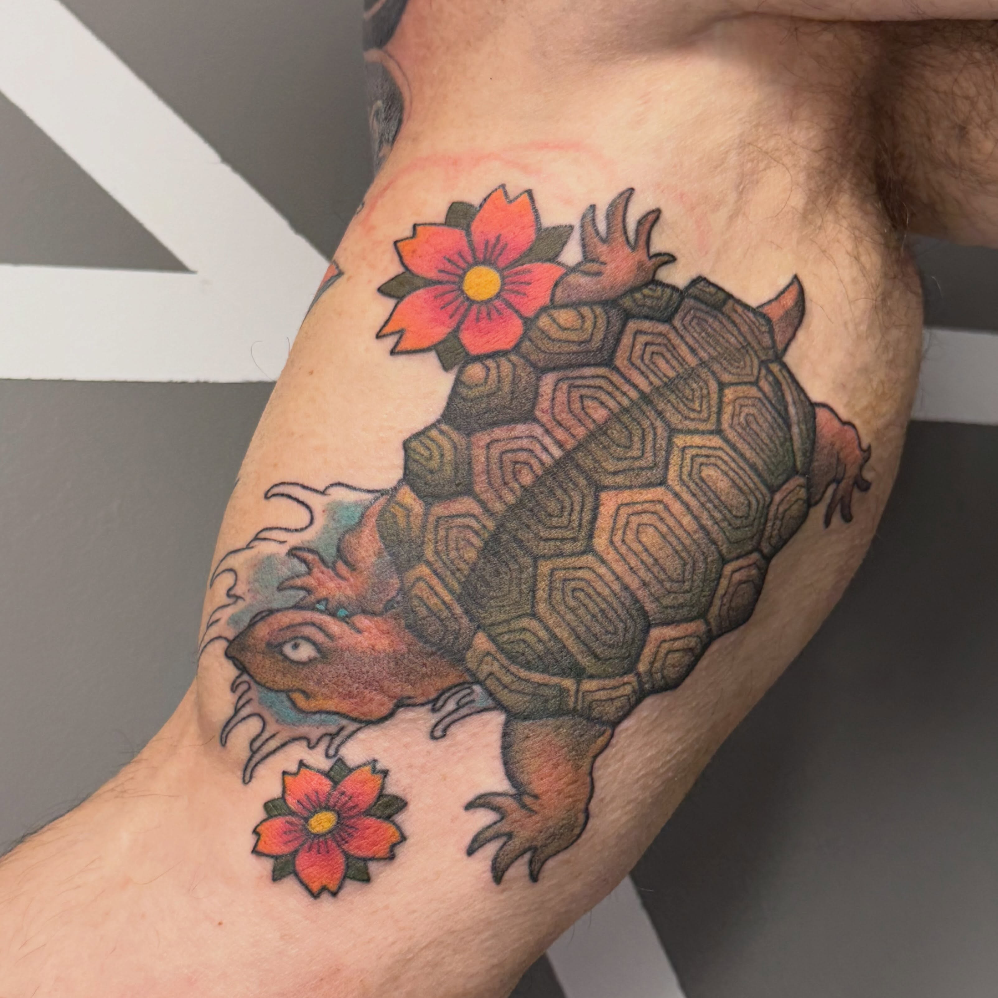 Turtle with flowers American traditional tattoo on the thigh by Katie Rojas