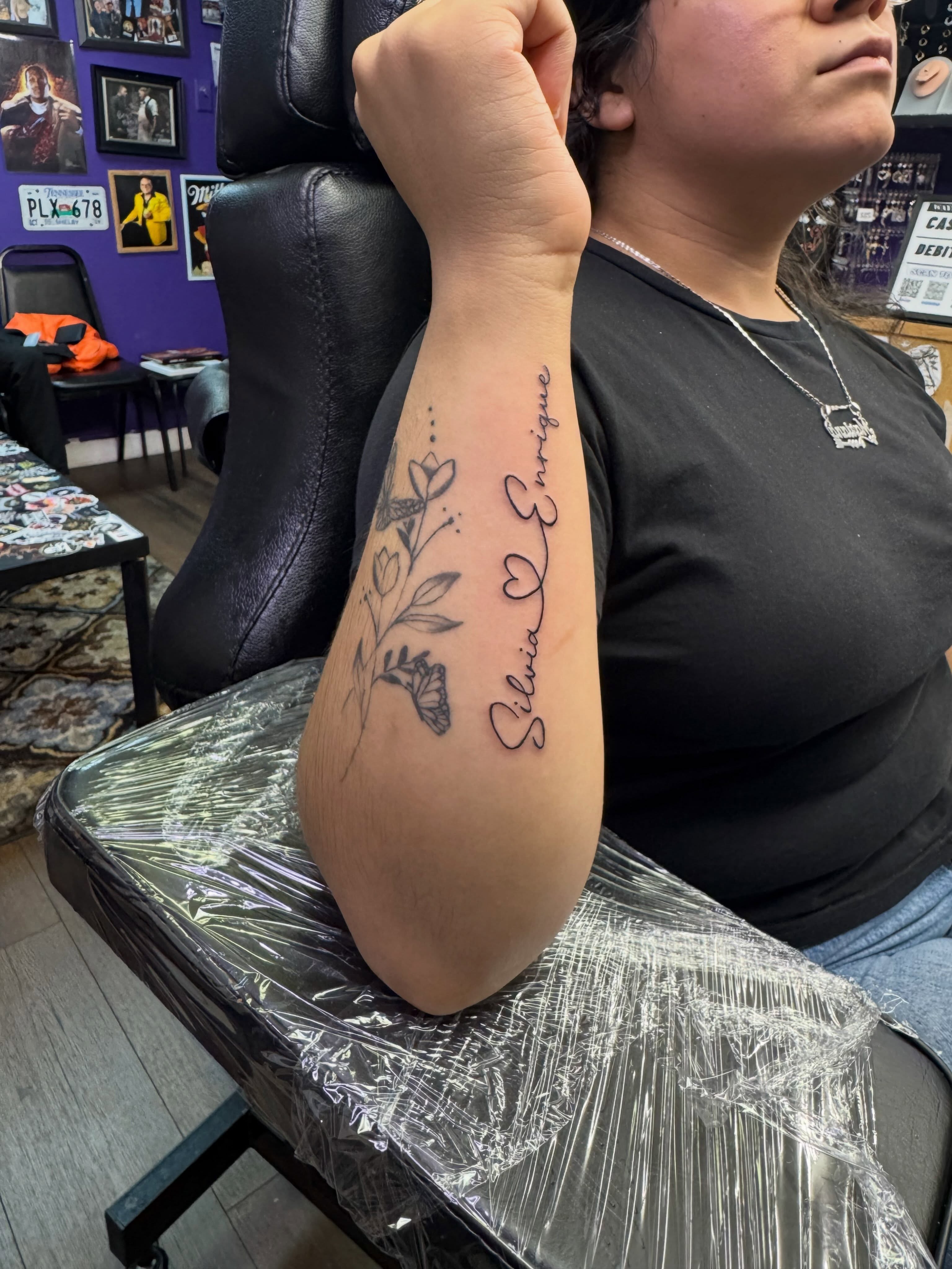 Floral design with name black and grey tattoo on the forearm by Christian Goines, Memphis, Tennessee