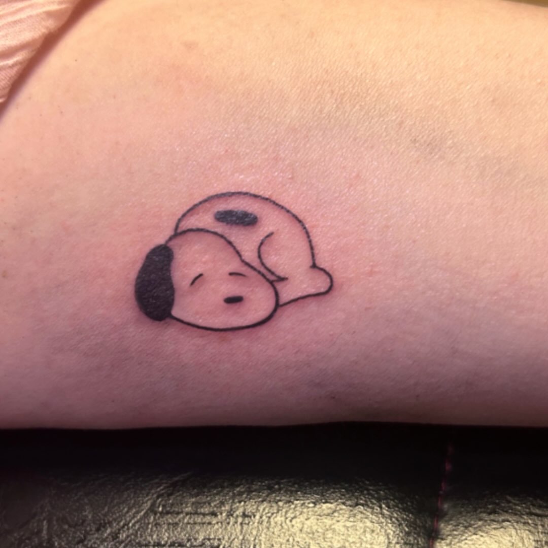 Sleeping dog minimalist tattoo on the forearm by Ashley Lambert