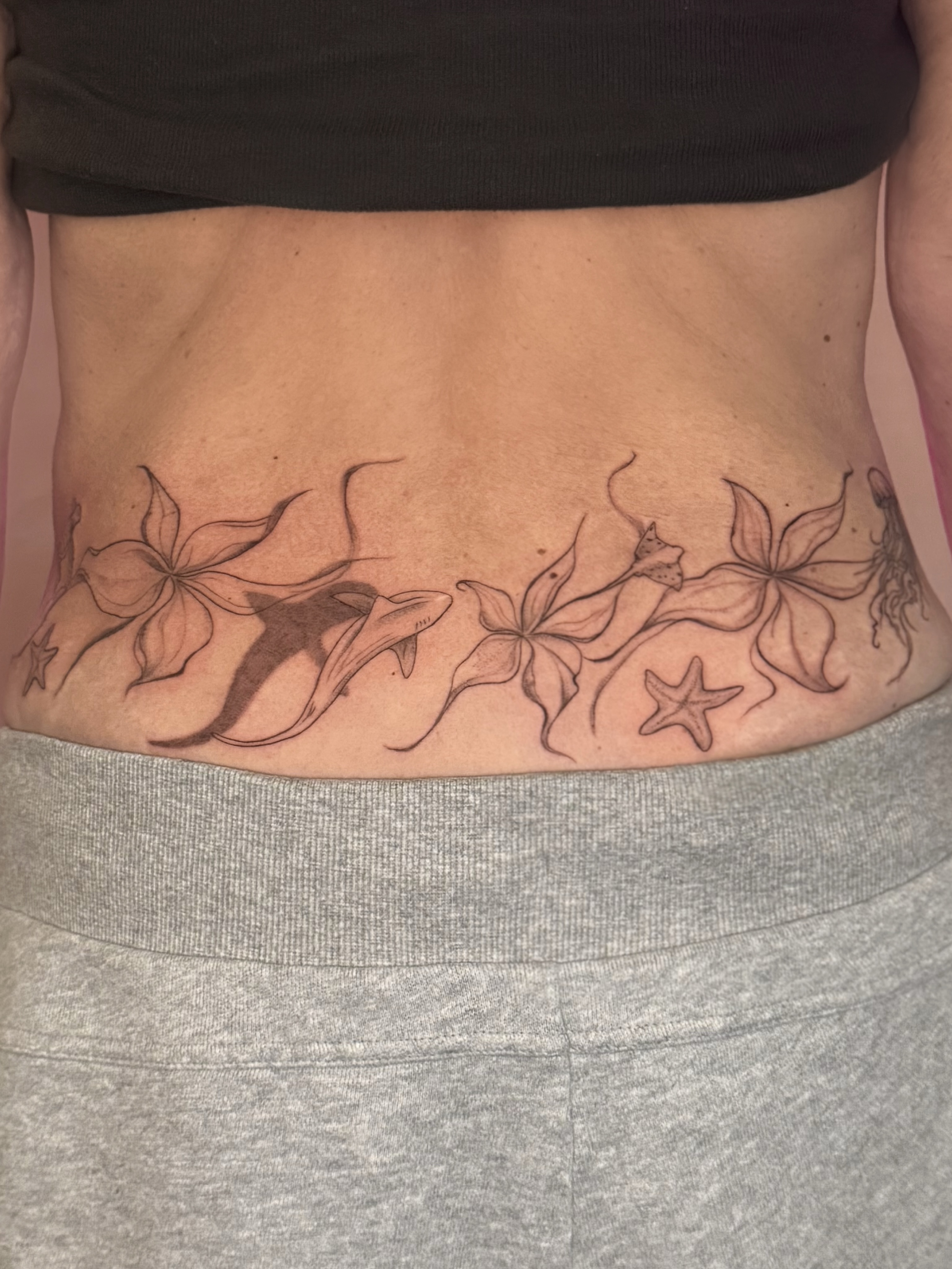 Dolphins and flowers black and grey tattoo on the torso by fine line tattoo artist▪️Austin TX