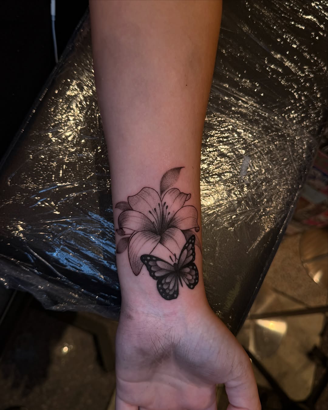 Lily and butterfly fine line tattoo on the forearm by ๐๐ข๐ฃ๐ฑ ๐๐ฆ๐ฑ๐ฌ ๐๏ธ