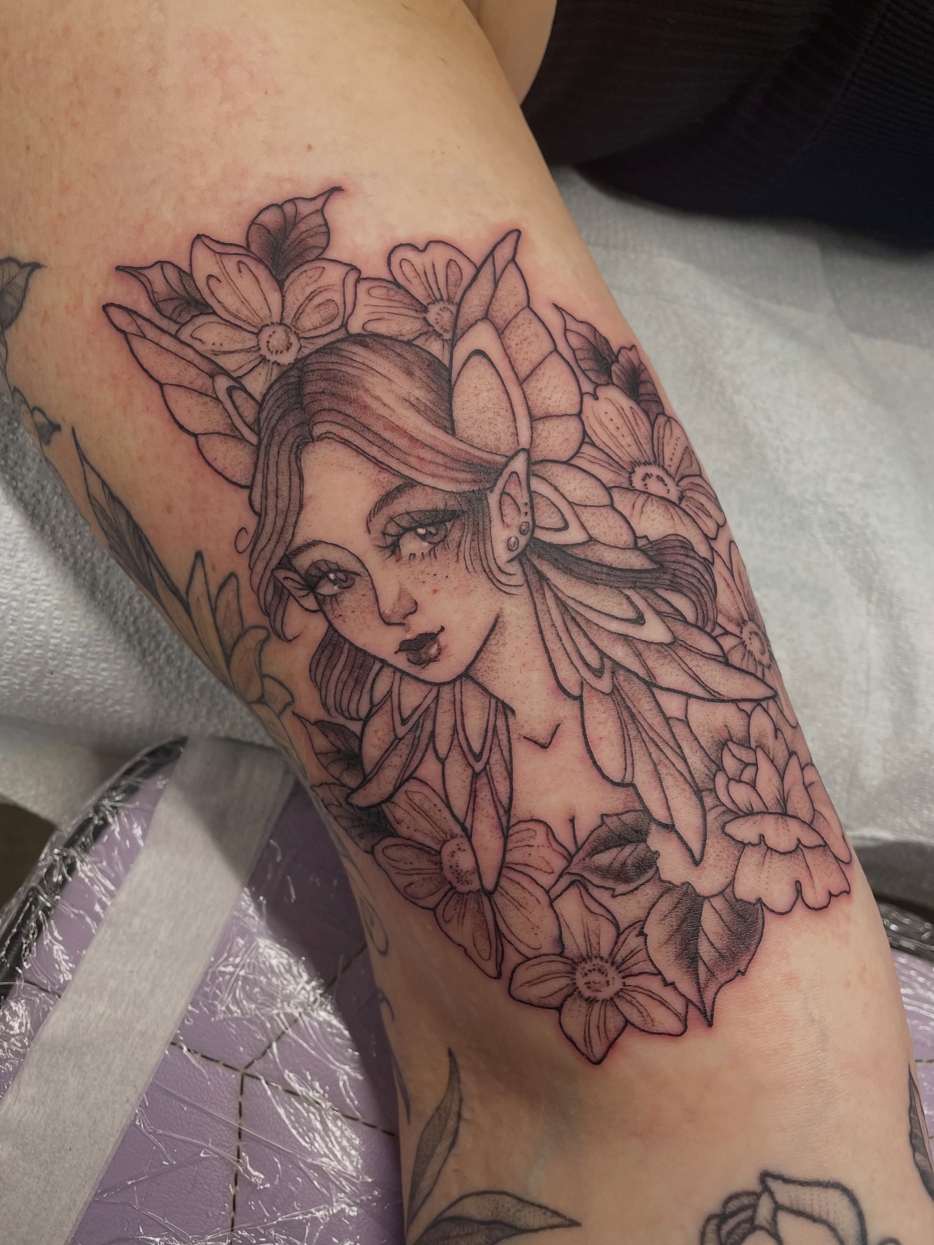 Elf with flowers realism tattoo on the forearm by Fionna Fanning