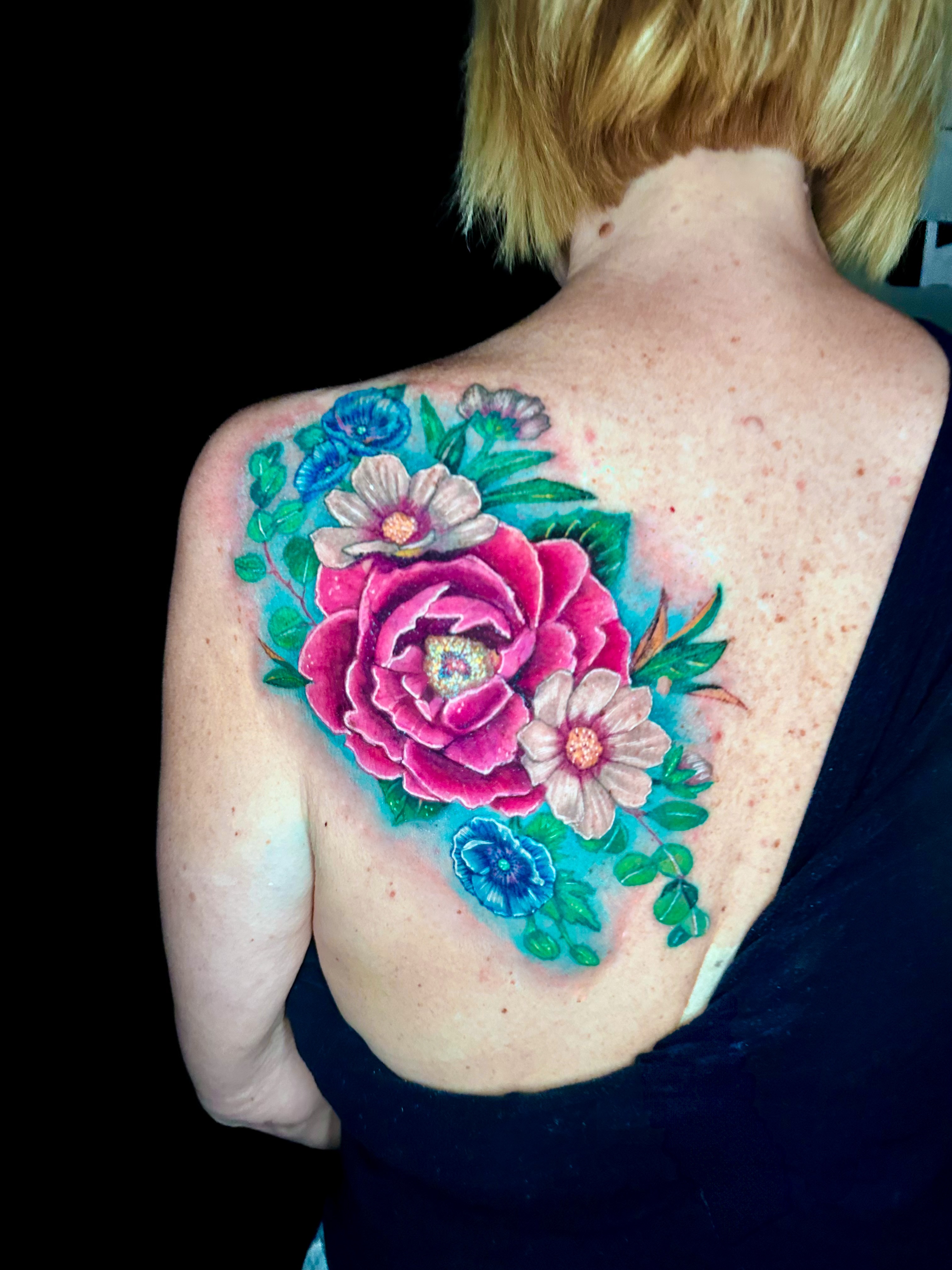 Floral bouquet realism tattoo on the back by Goga