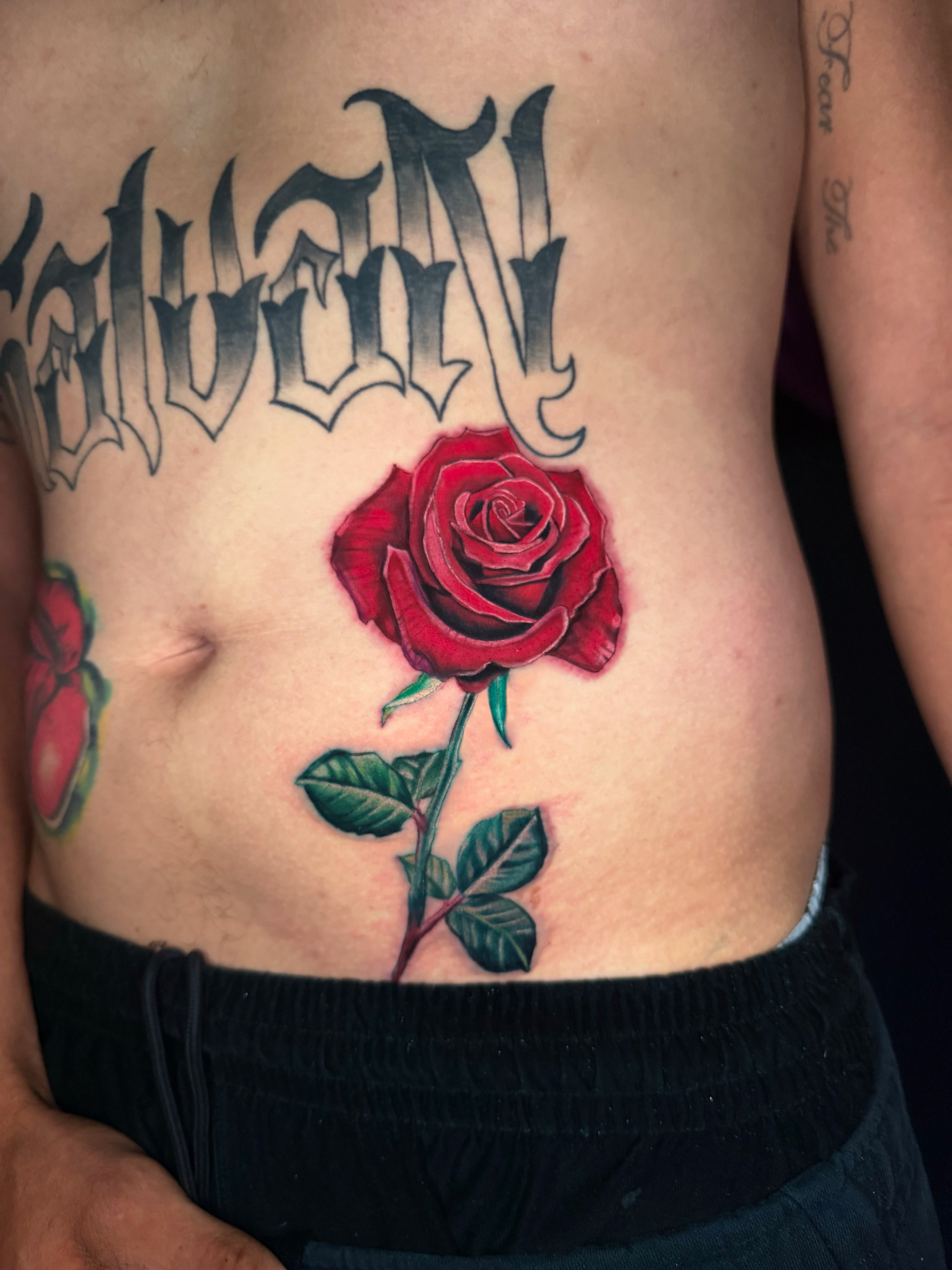 Red rose realism tattoo on the ribs by Goga