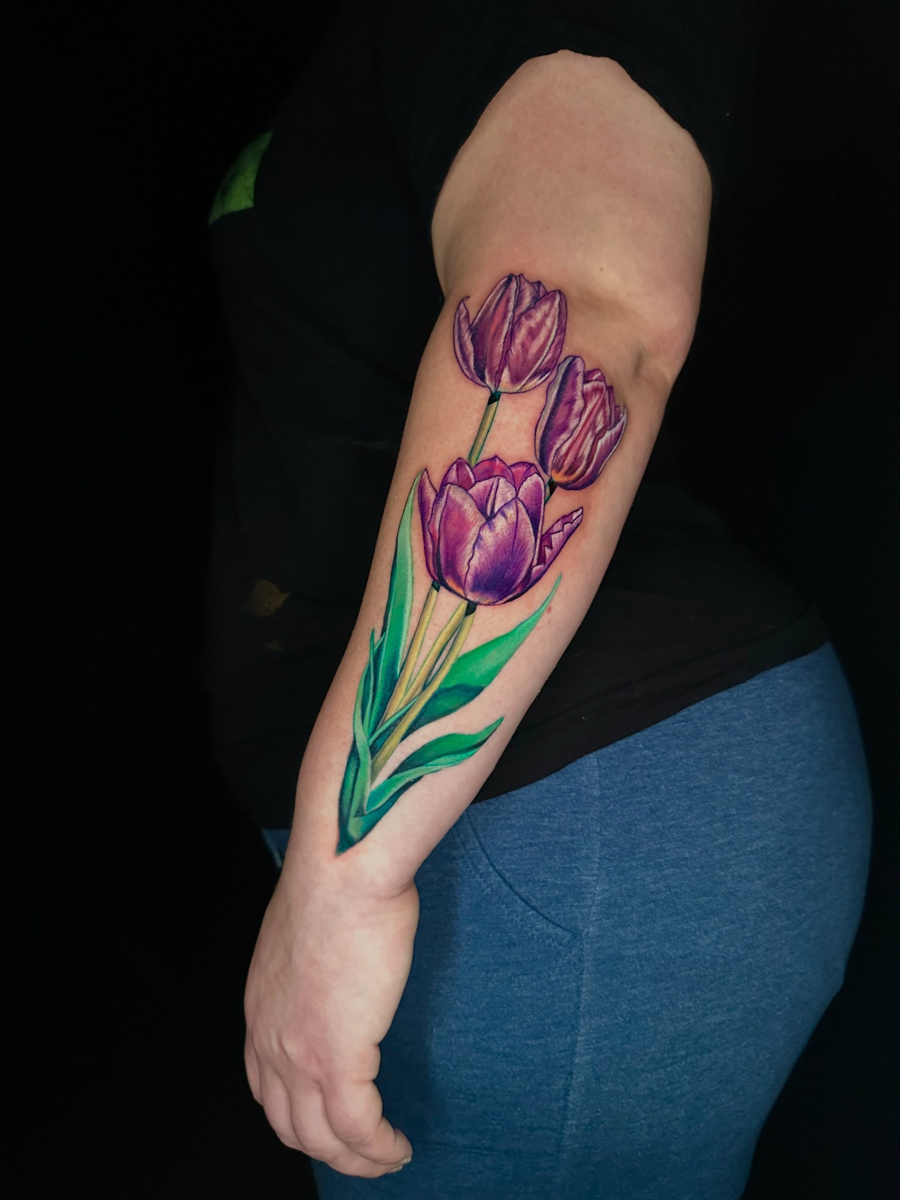 Purple tulips realism tattoo on the forearm by Goga