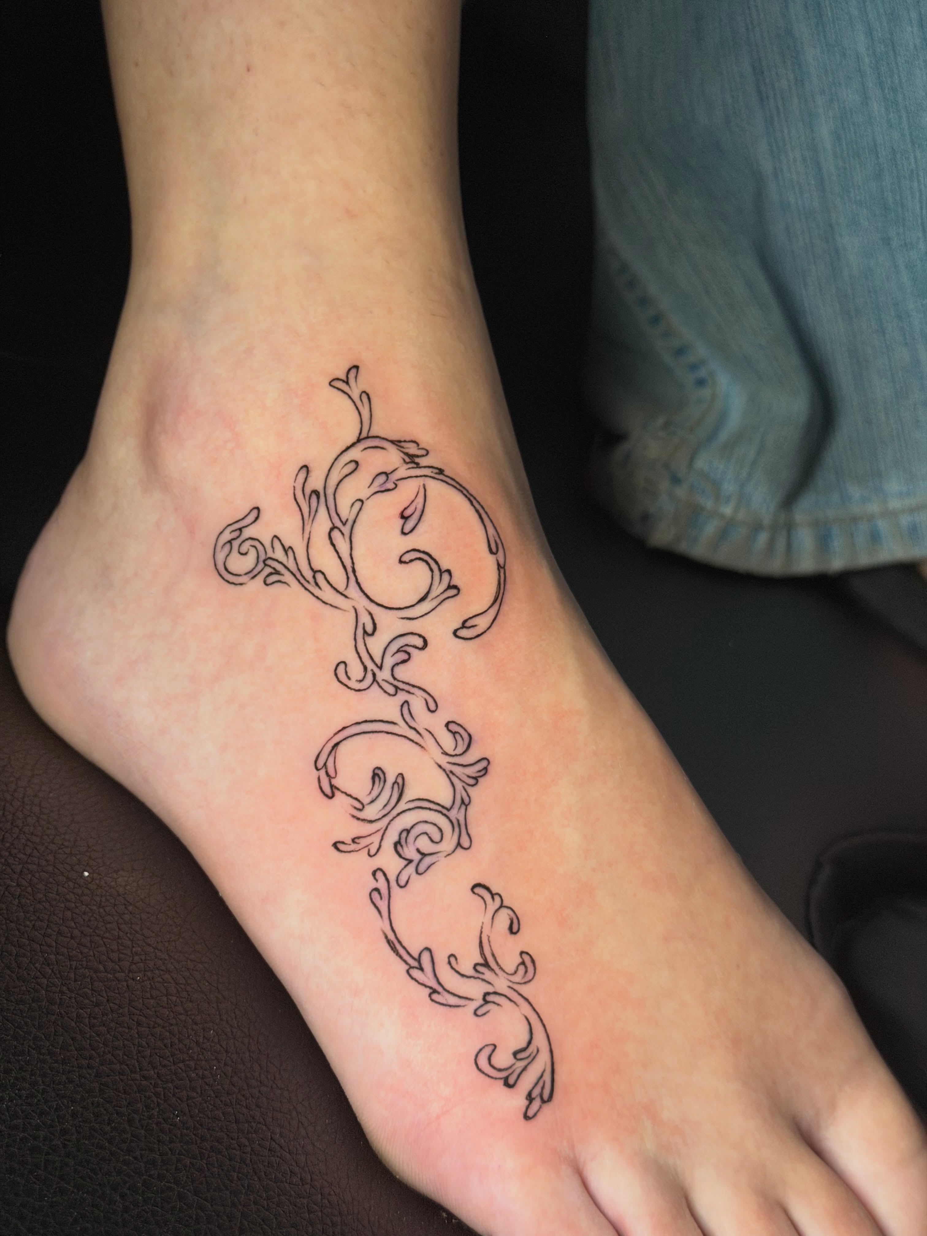 Scrollwork ornamental tattoo on the foot by tattoo artist (mollz)