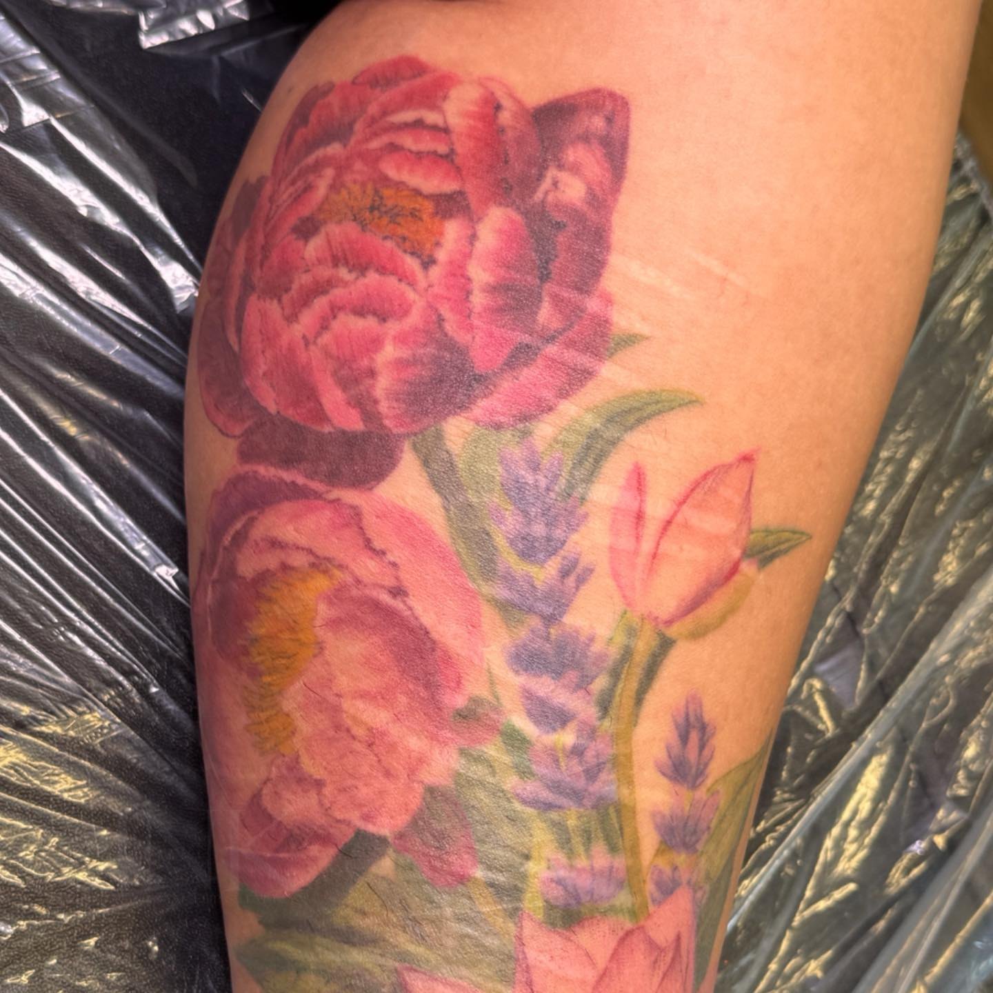 Floral bouquet realism tattoo on the thigh by PxINK, Crystal, Minnesota