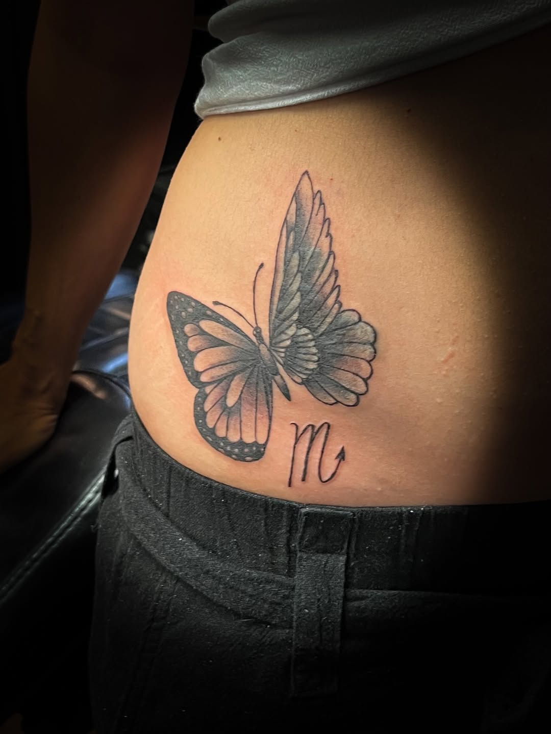 Butterfly and letter m fine line tattoo on the ribs by Melissa Peña NYC