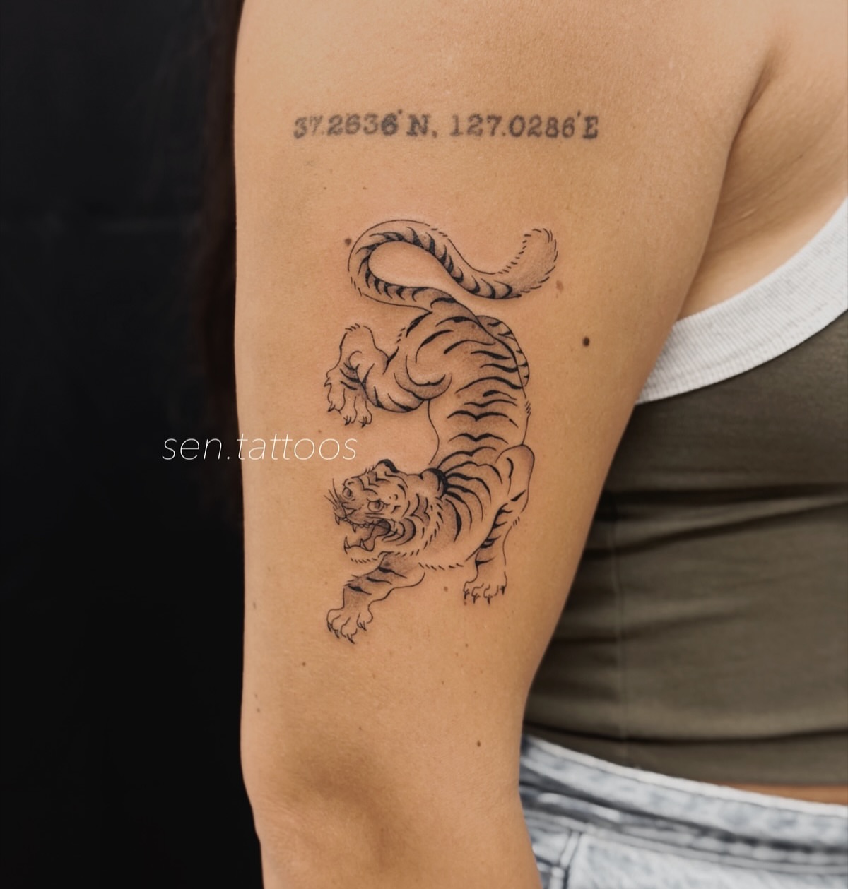Tiger black and grey tattoo on the upper arm by Sen Tattooer