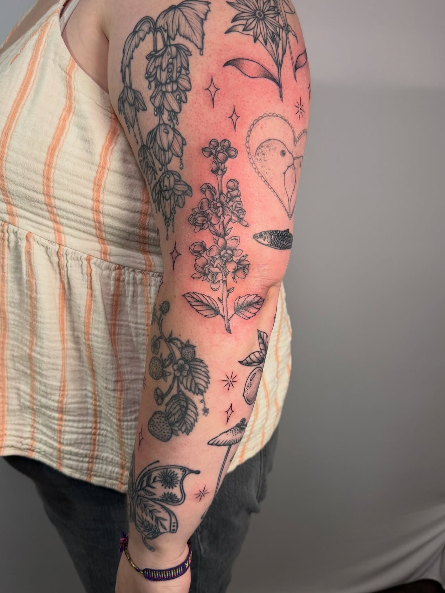 Botanical and bird motifs black and grey tattoo on the forearm by Jenna Nicole