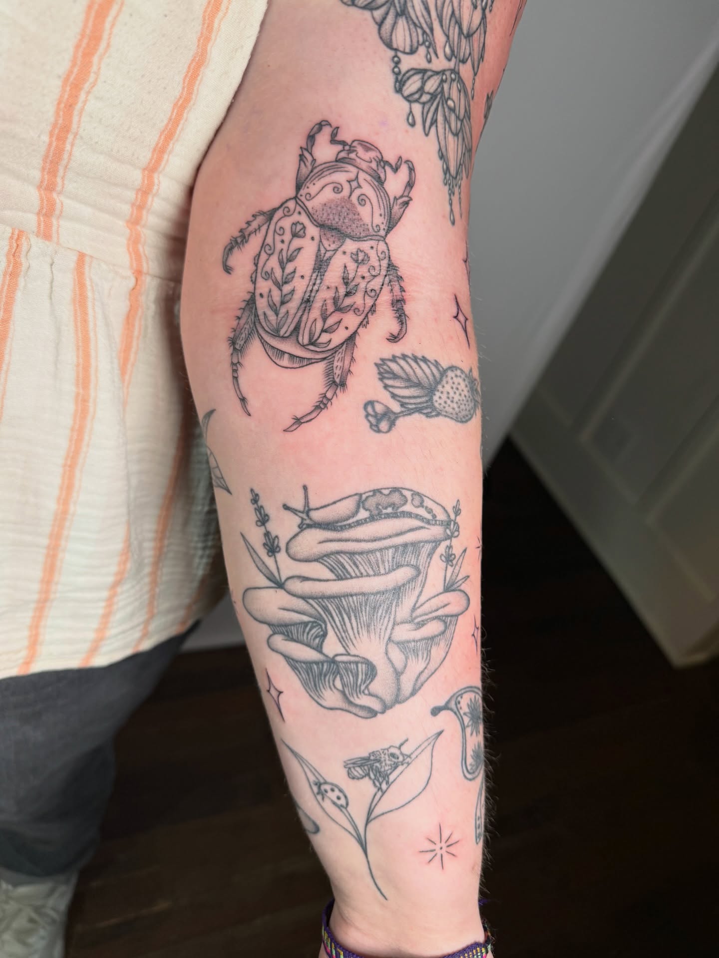 Beetle and mushroom black and grey tattoo on the forearm by Jenna Nicole