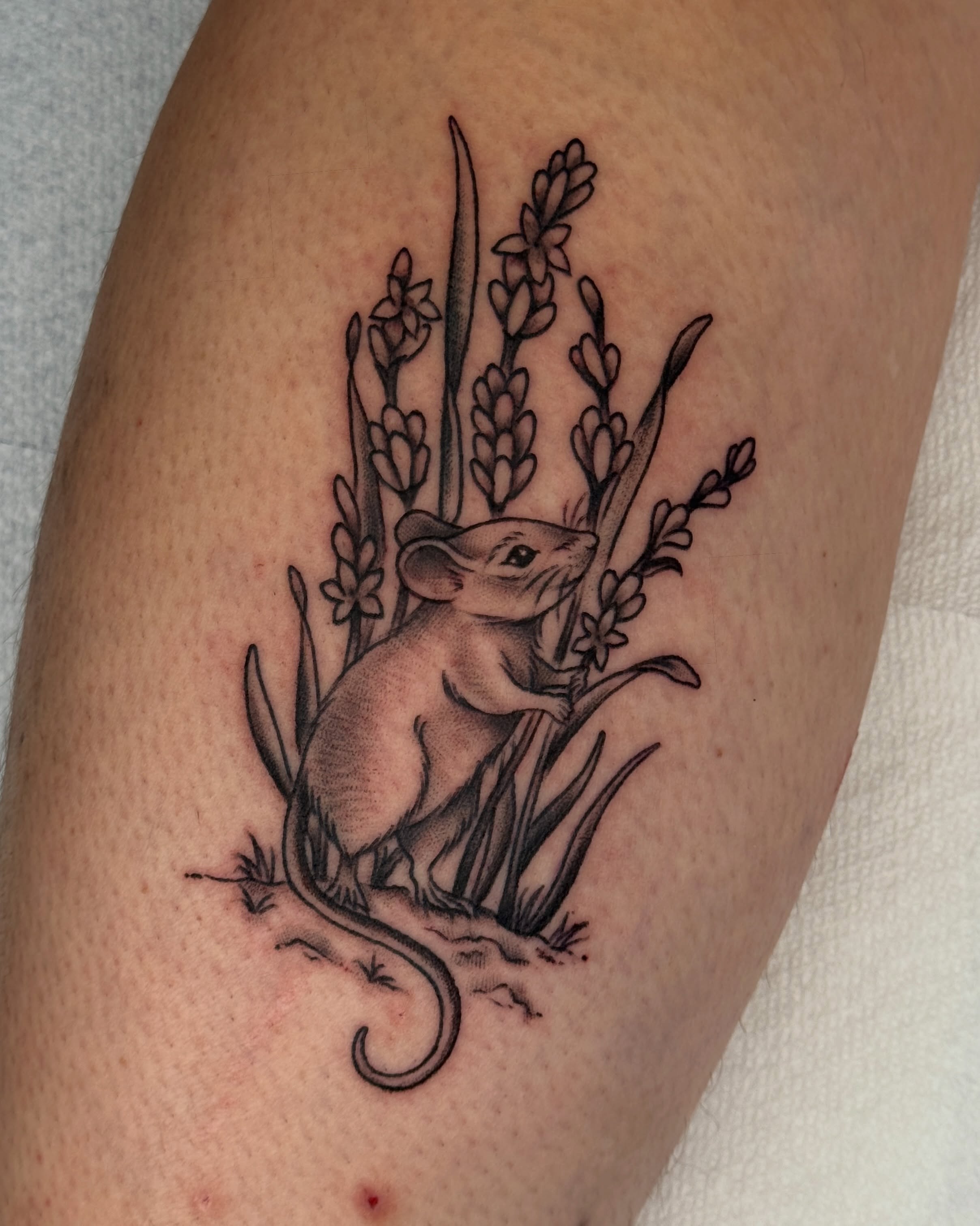 Mouse among flowers black and grey tattoo on the thigh by Bre Grover, Vancouver, British Columbia