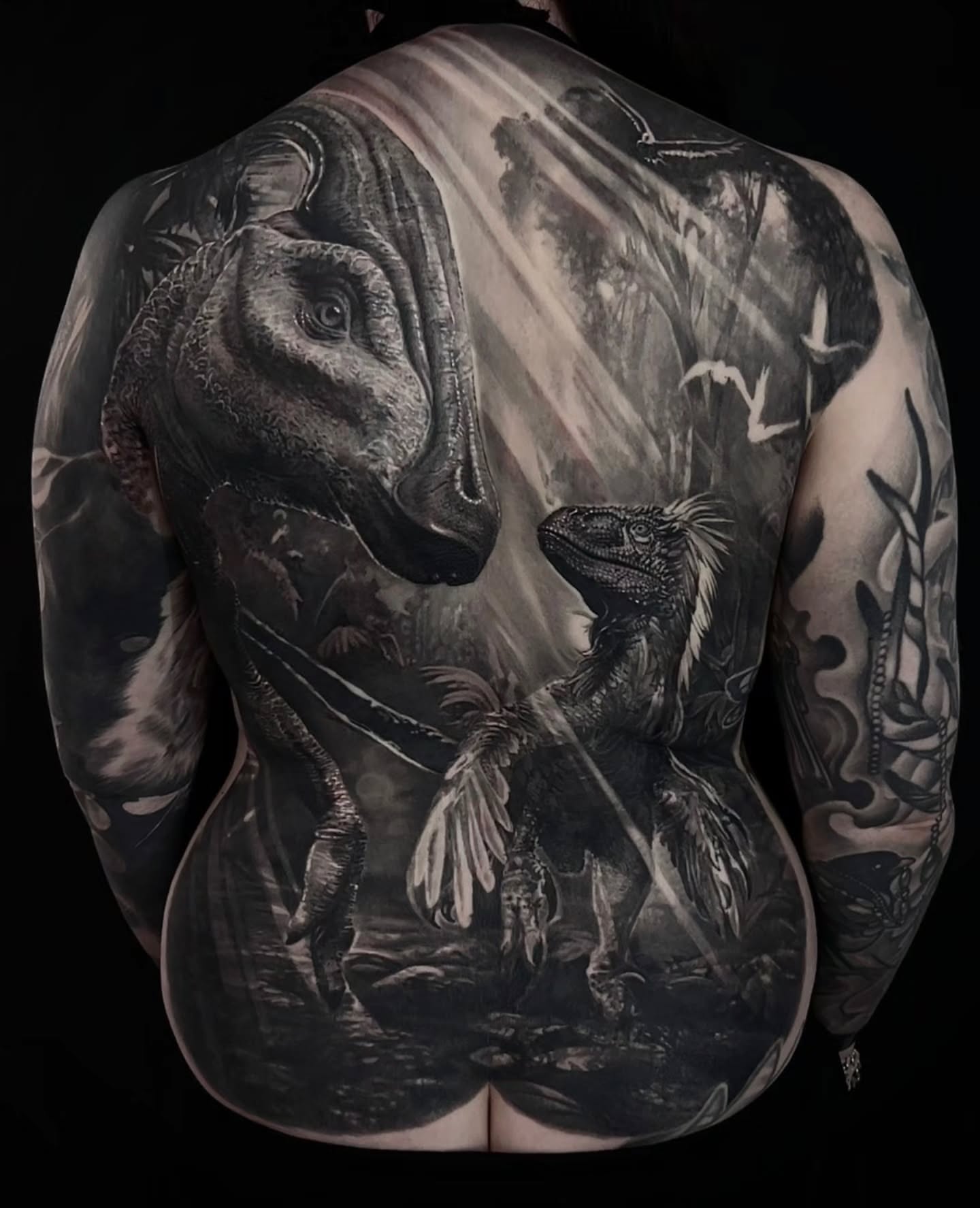 Dinosaurs realism tattoo on the back by Owen Paulls
