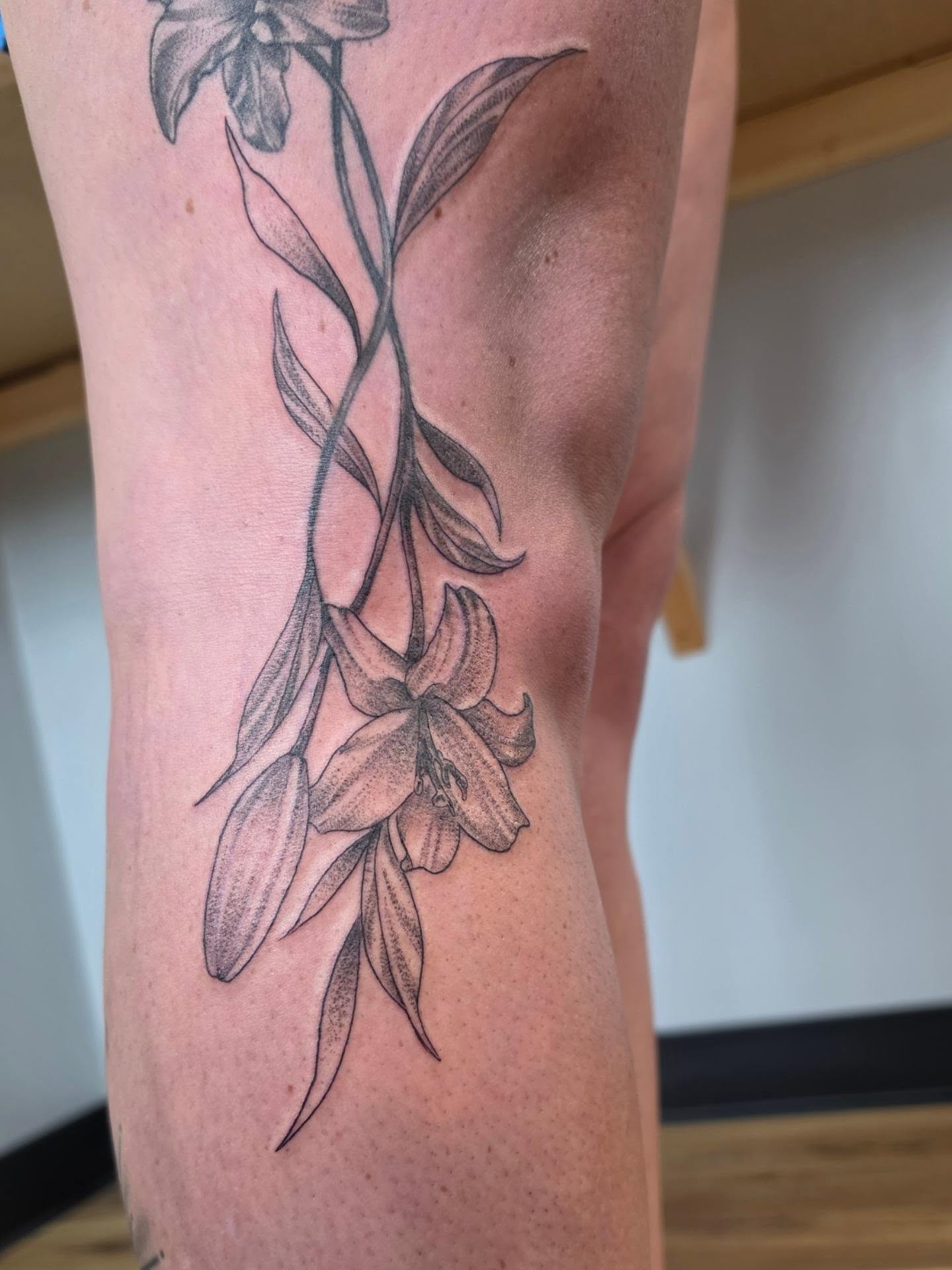 Lily black and grey tattoo on the leg by Colleen