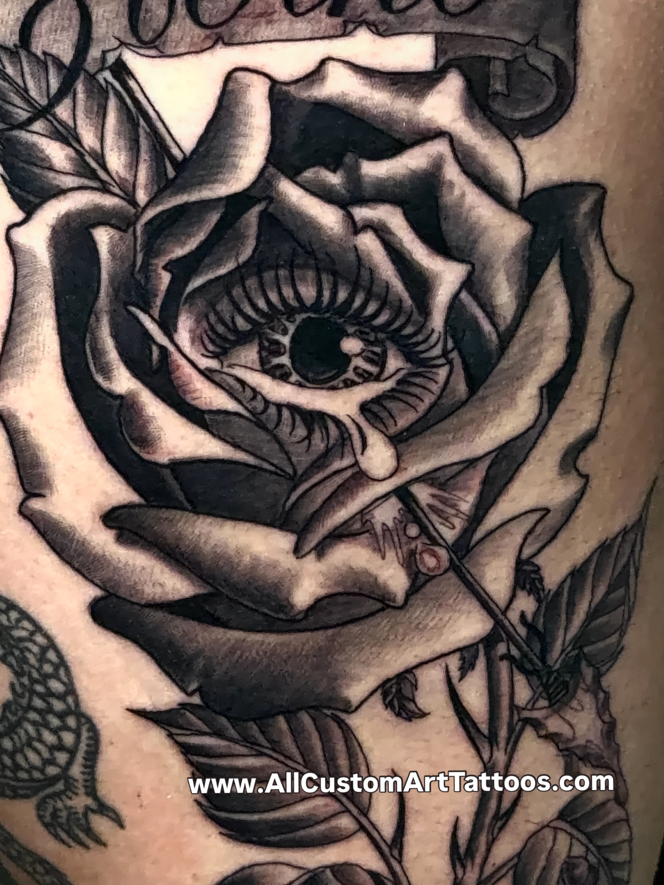 Eye within rose realism tattoo on the upper arm by Rafael Marte, White Plains, New York