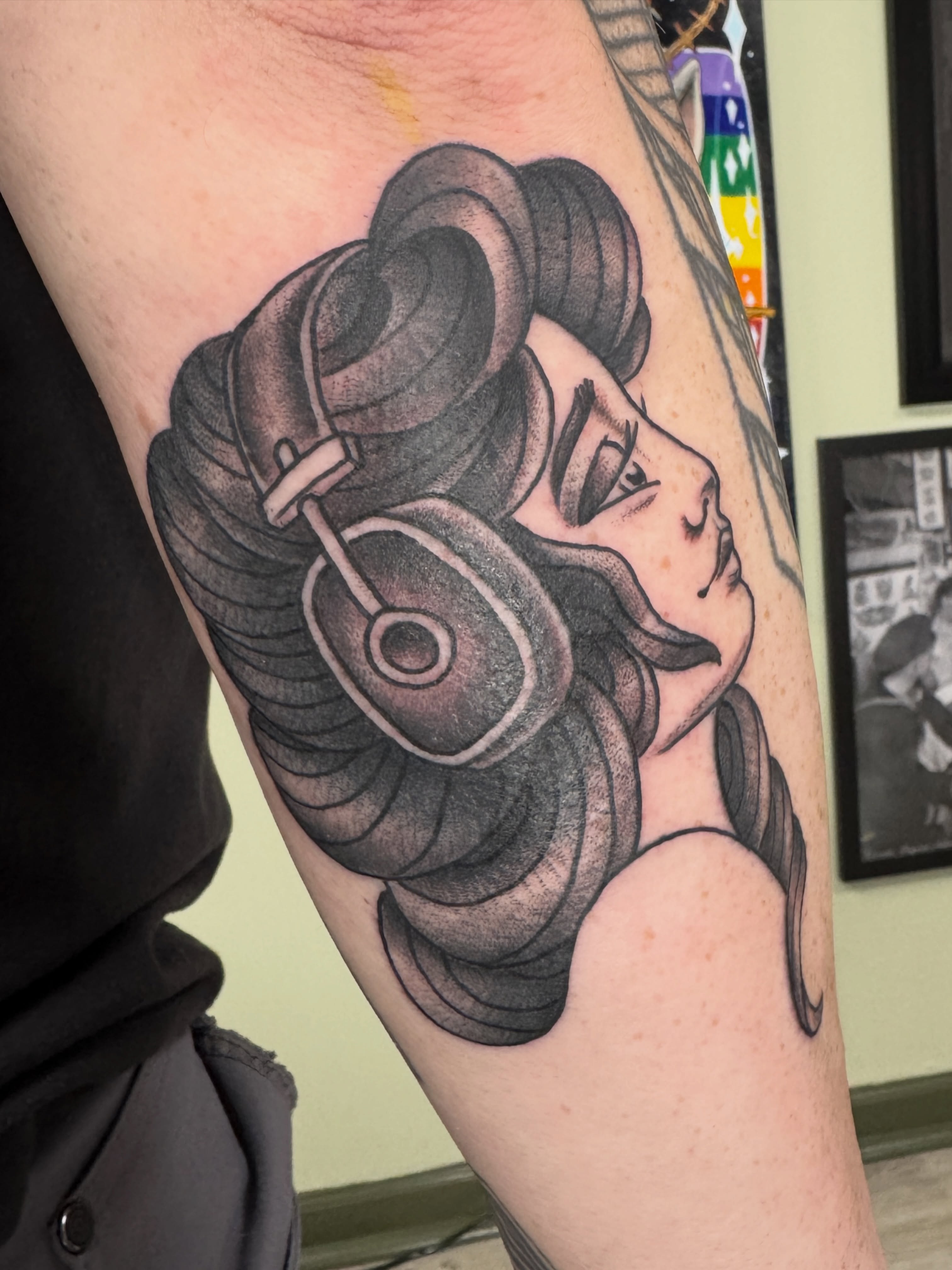 Woman with headphones realism tattoo on the forearm by Joel Smith, Manhattan, Kansas