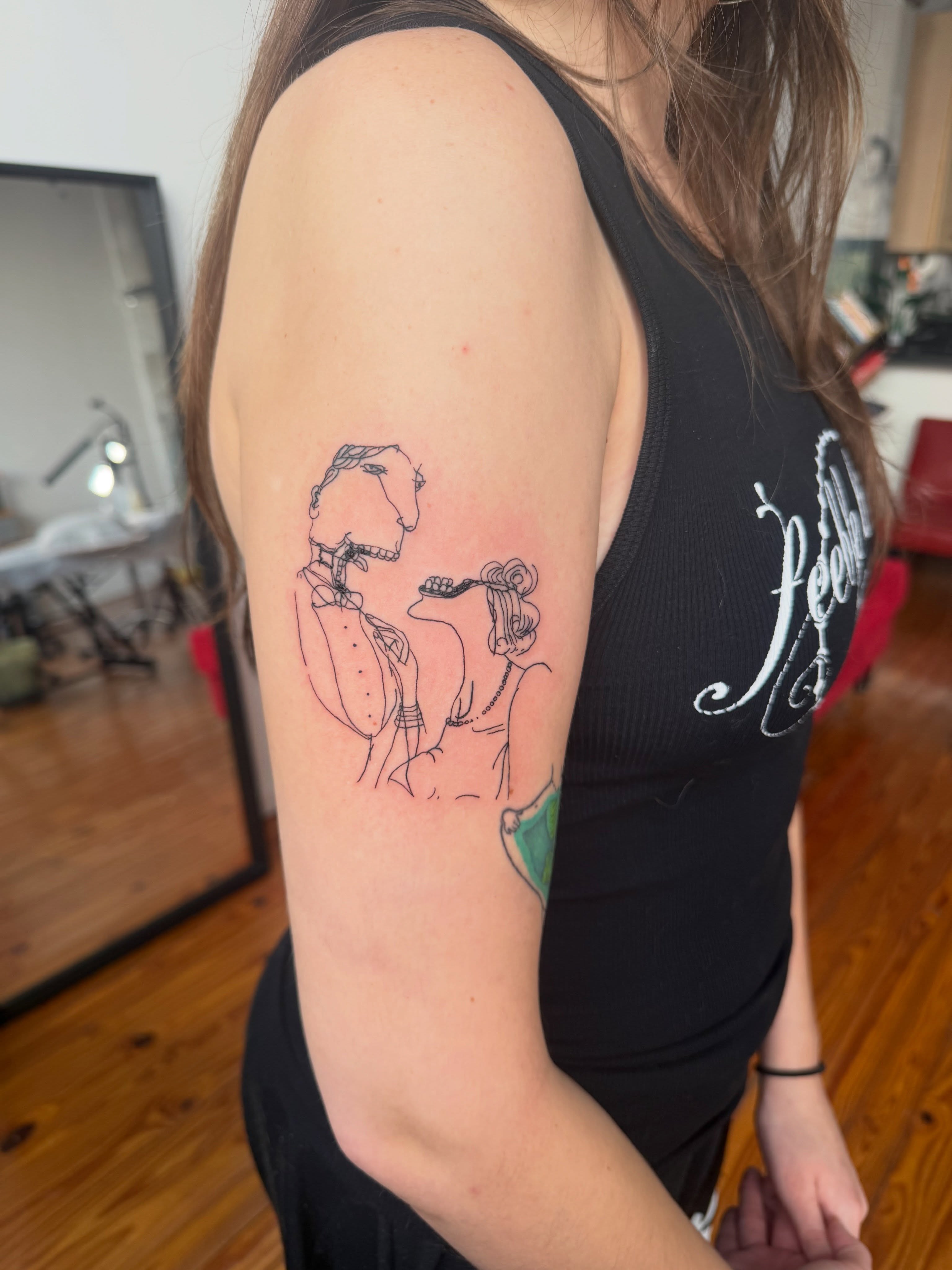 Man and woman illustrative tattoo on the upper arm by Jose Javier