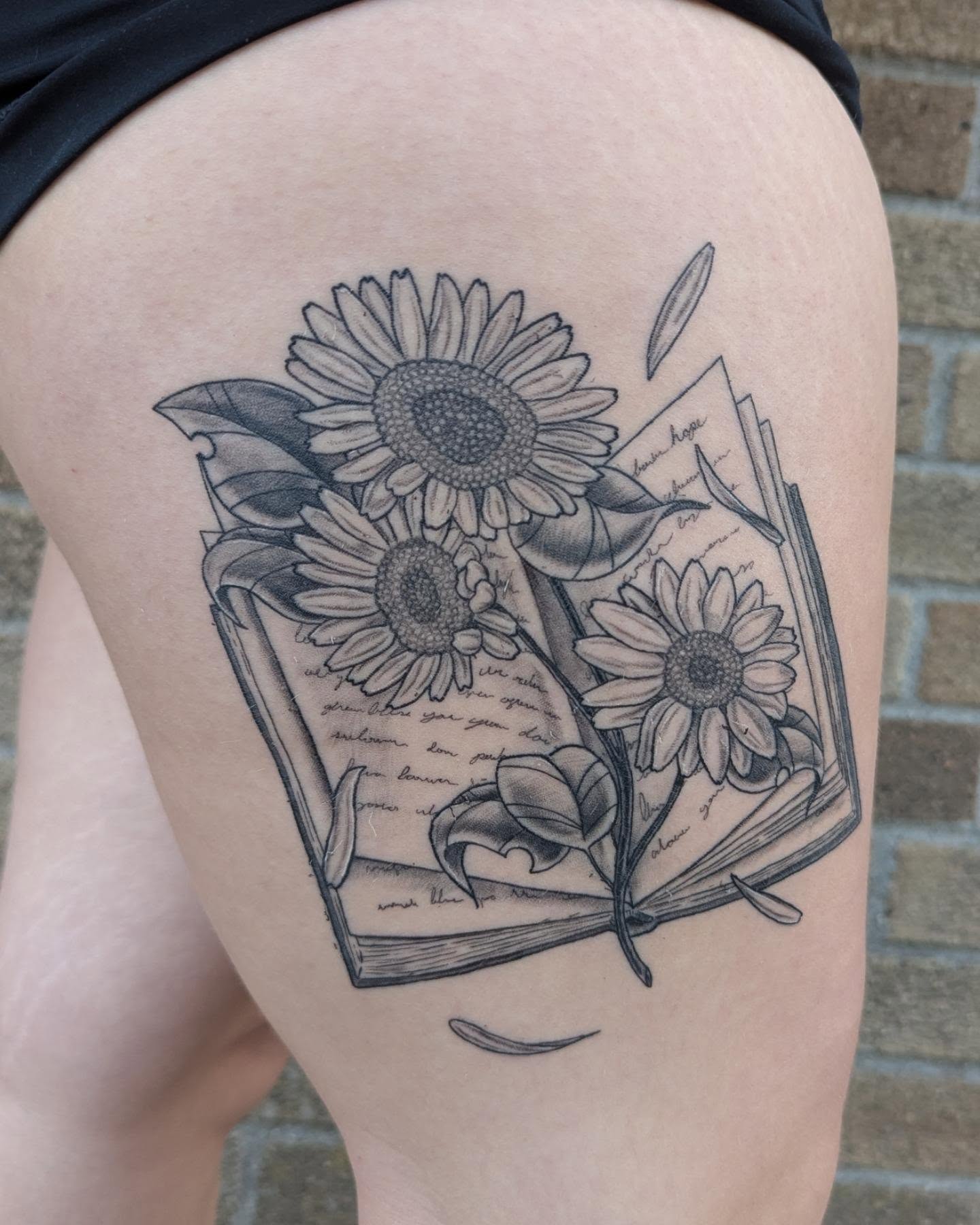 Sunflowers and book realism tattoo on the thigh by Hannah Hayes, Livonia, Michigan