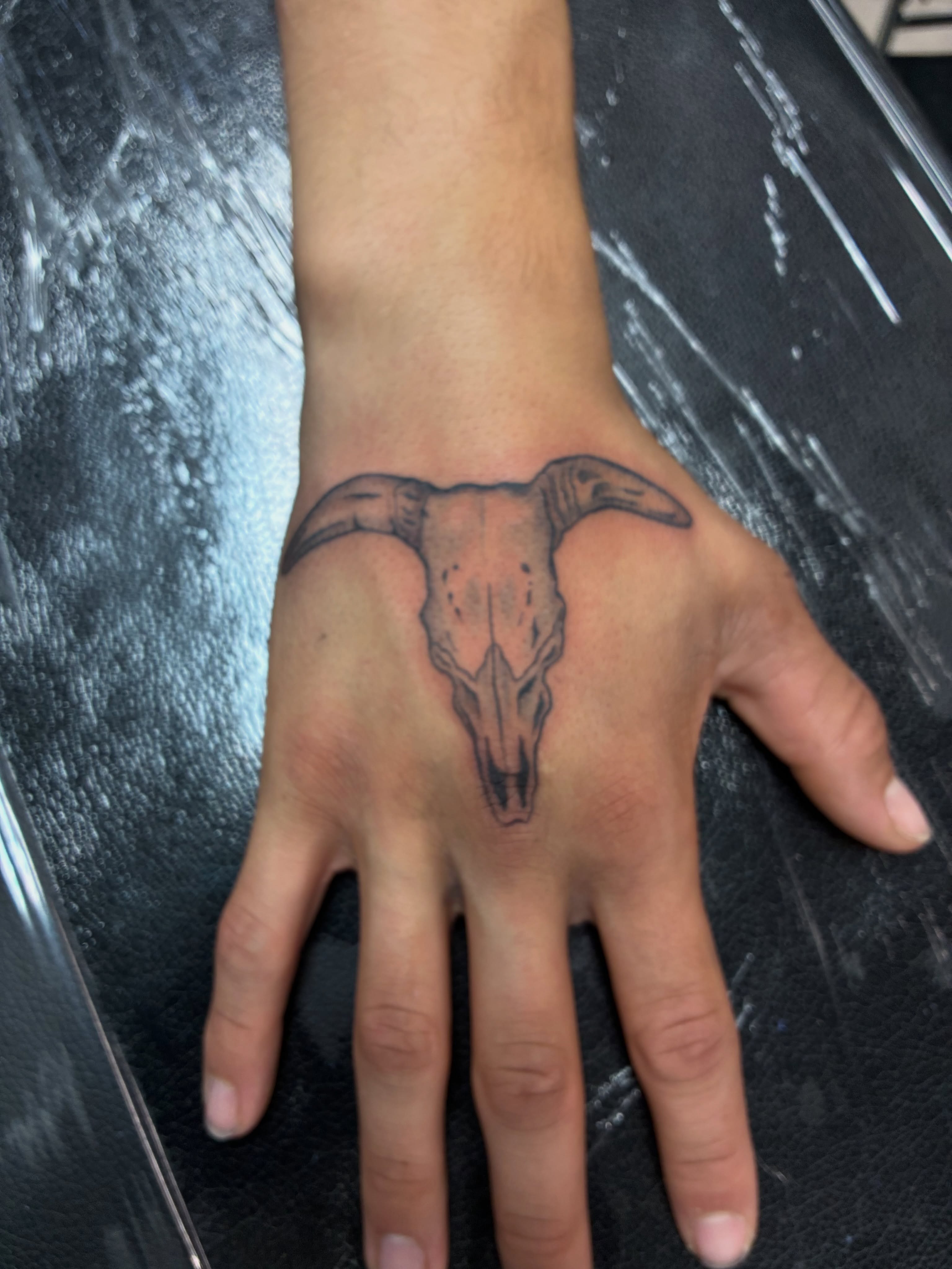 Bull skull black and grey tattoo on the hand by James Ostler