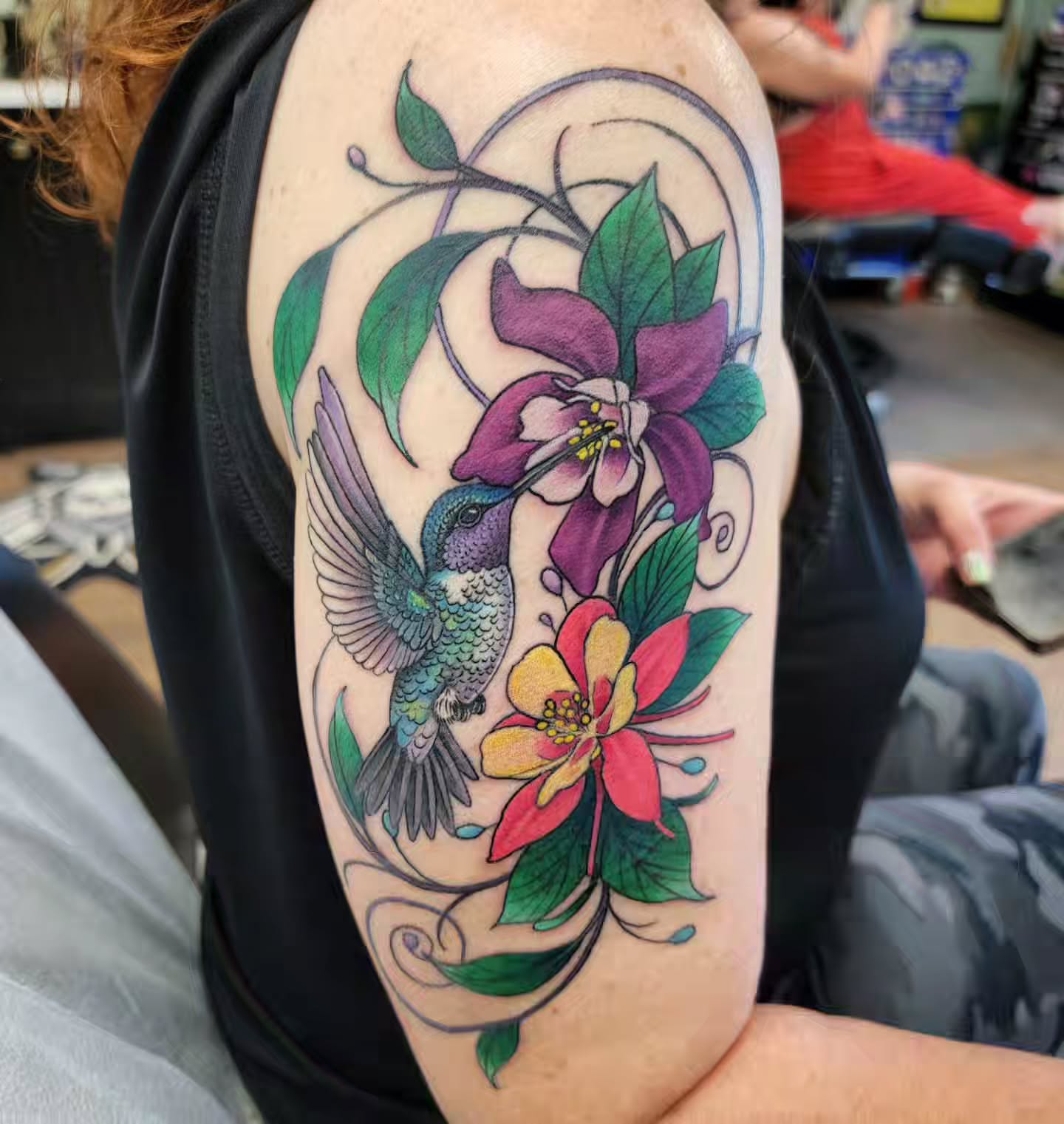 Hummingbird and flowers new school tattoo on the upper arm by Chantel Chan, Portland, Oregon
