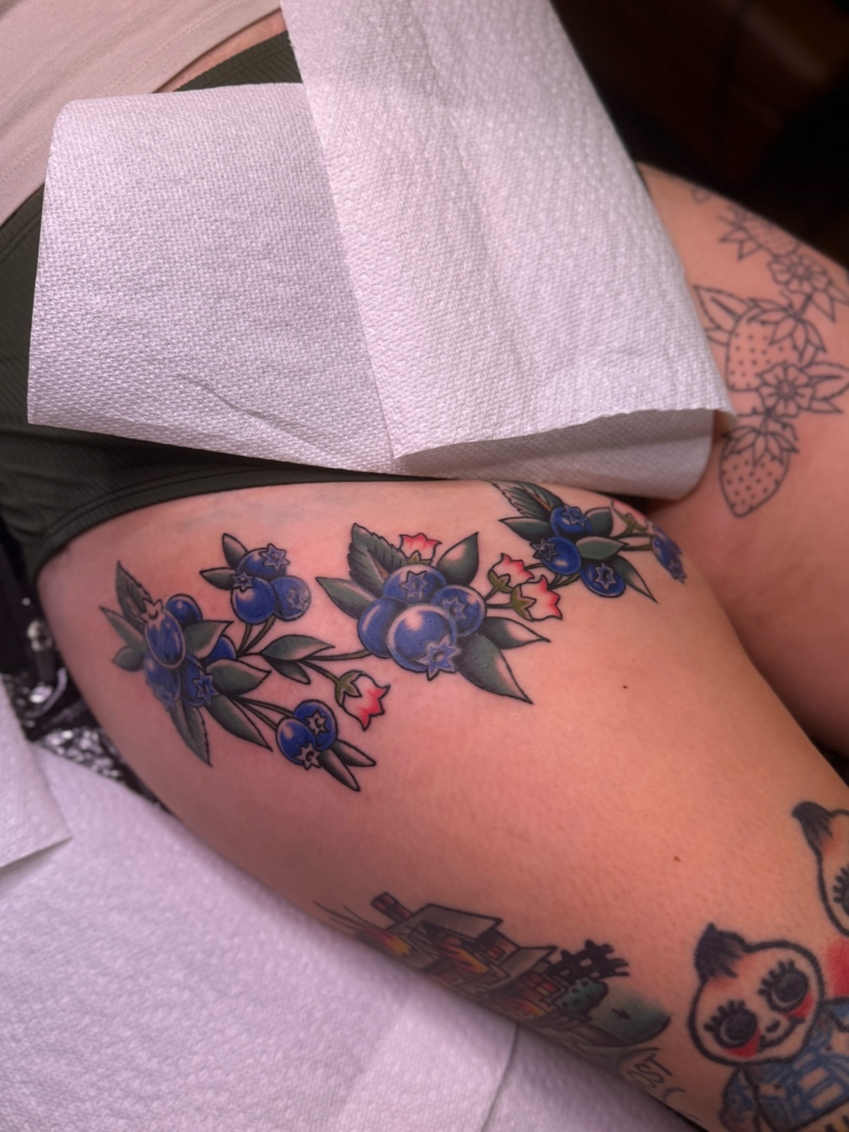 Blueberry bouquet American traditional tattoo on the thigh by Ethan, Toledo, Ohio