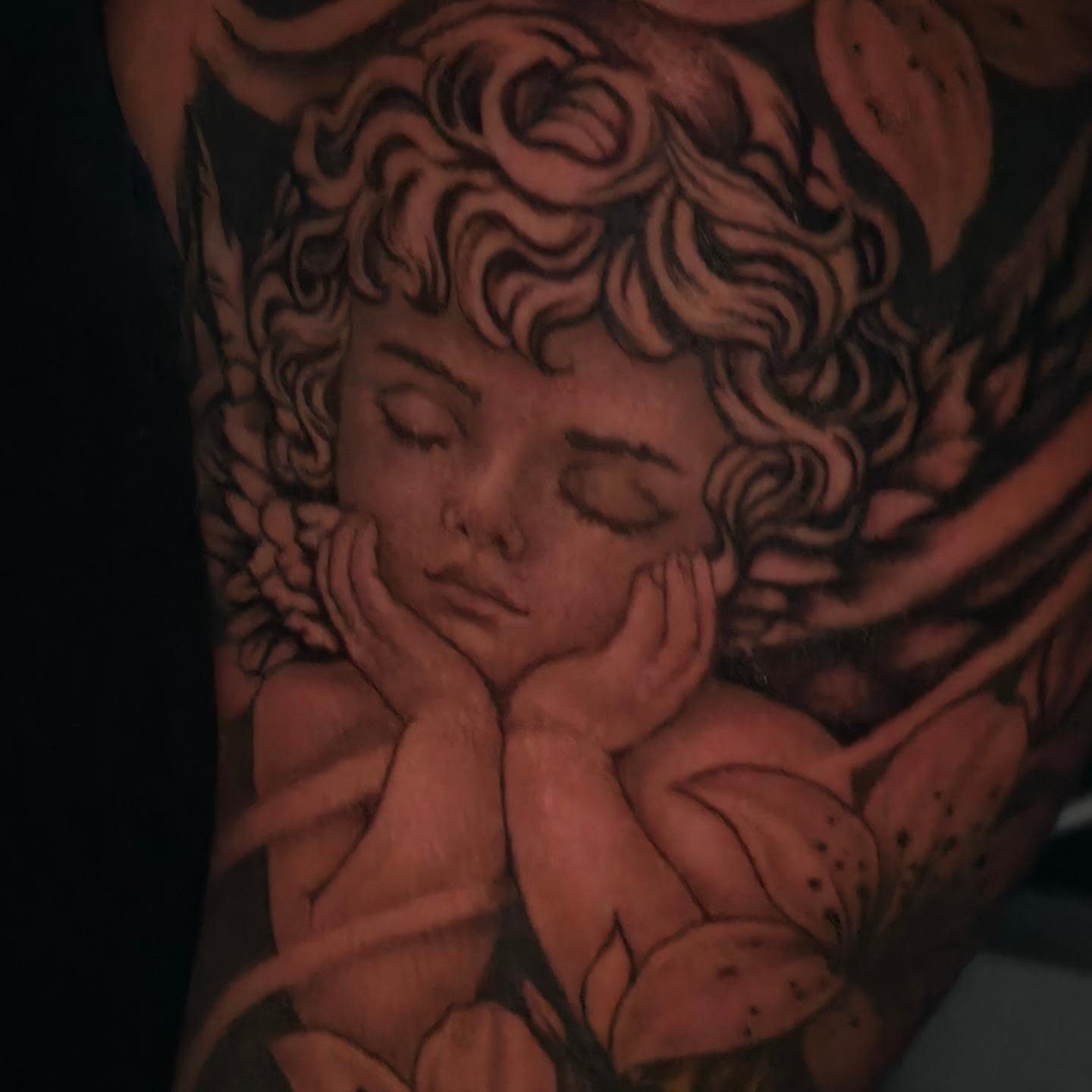 Sleeping child black and grey tattoo on the upper arm by Moose