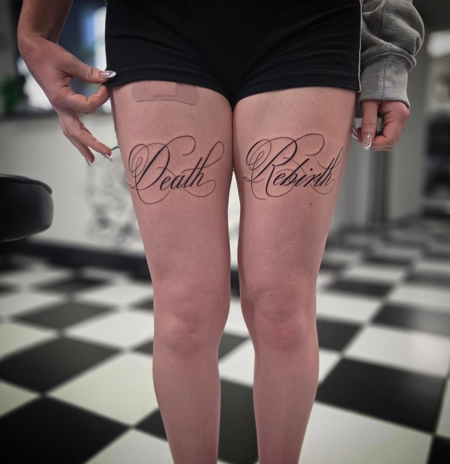 Death Rebirth lettering script tattoo on the thigh by Molly DeSmedt