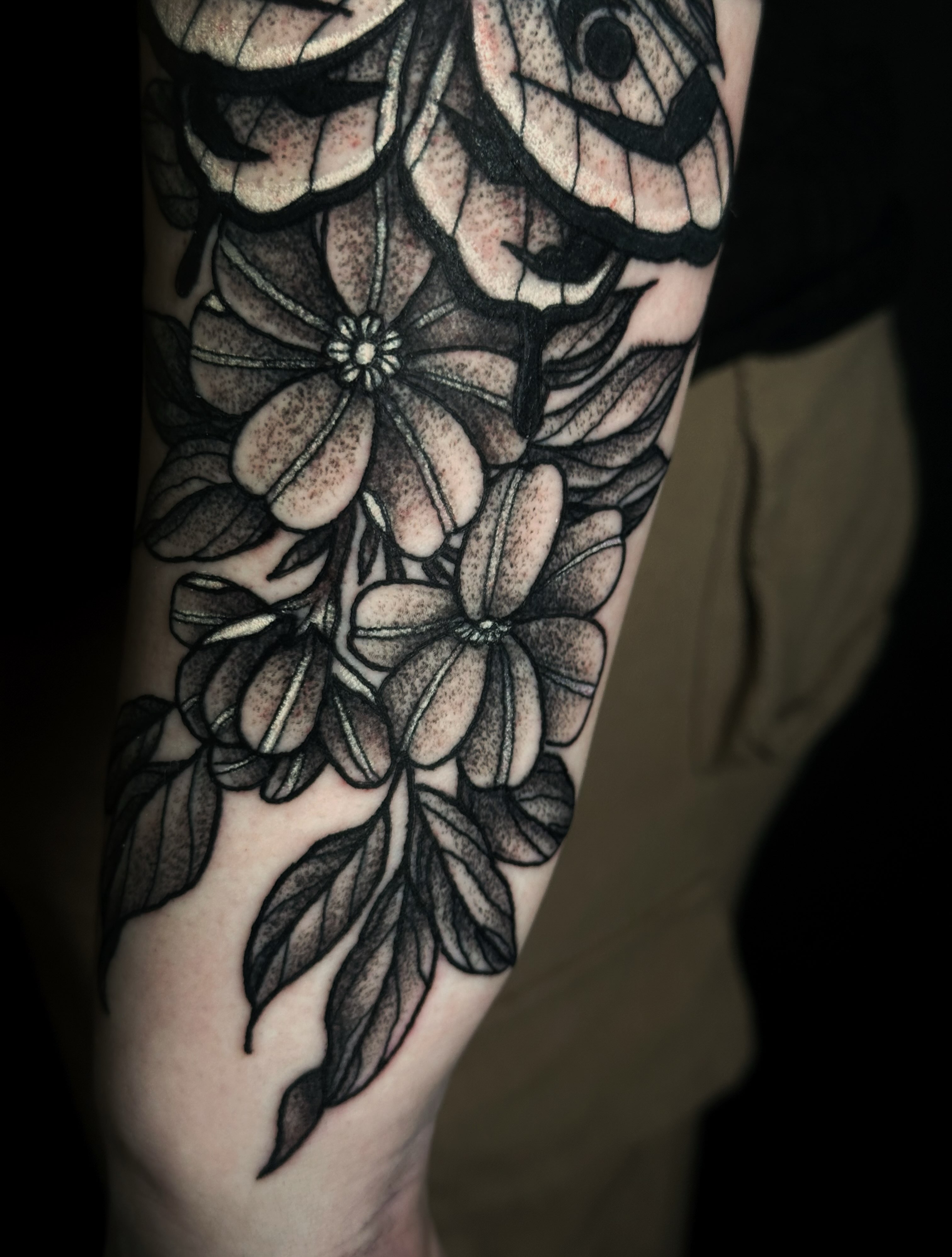 Flowers black and grey tattoo on the forearm by Elizabeth Tabler