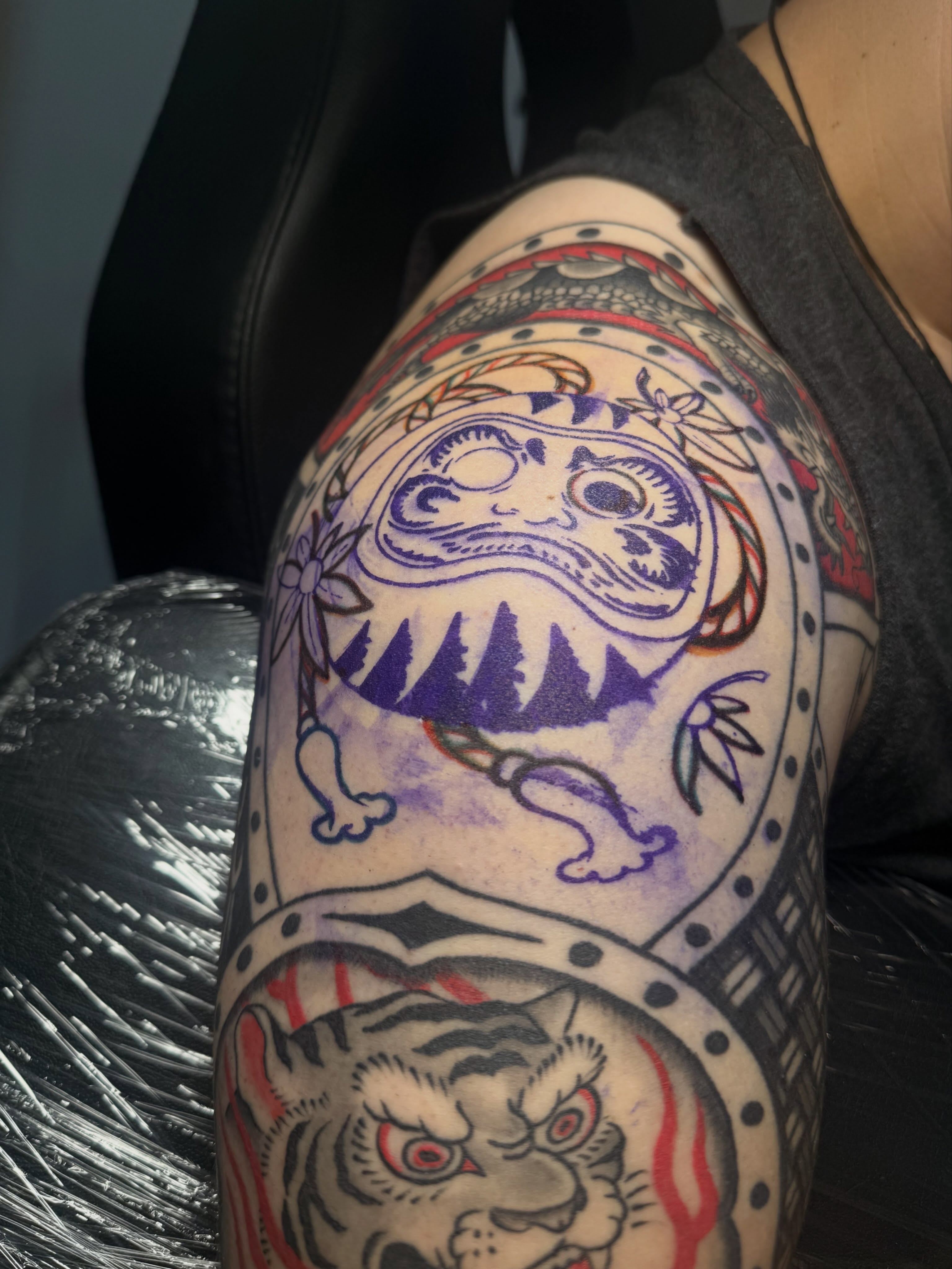 Tiger and mask American traditional tattoo on the thigh by Cory Allen