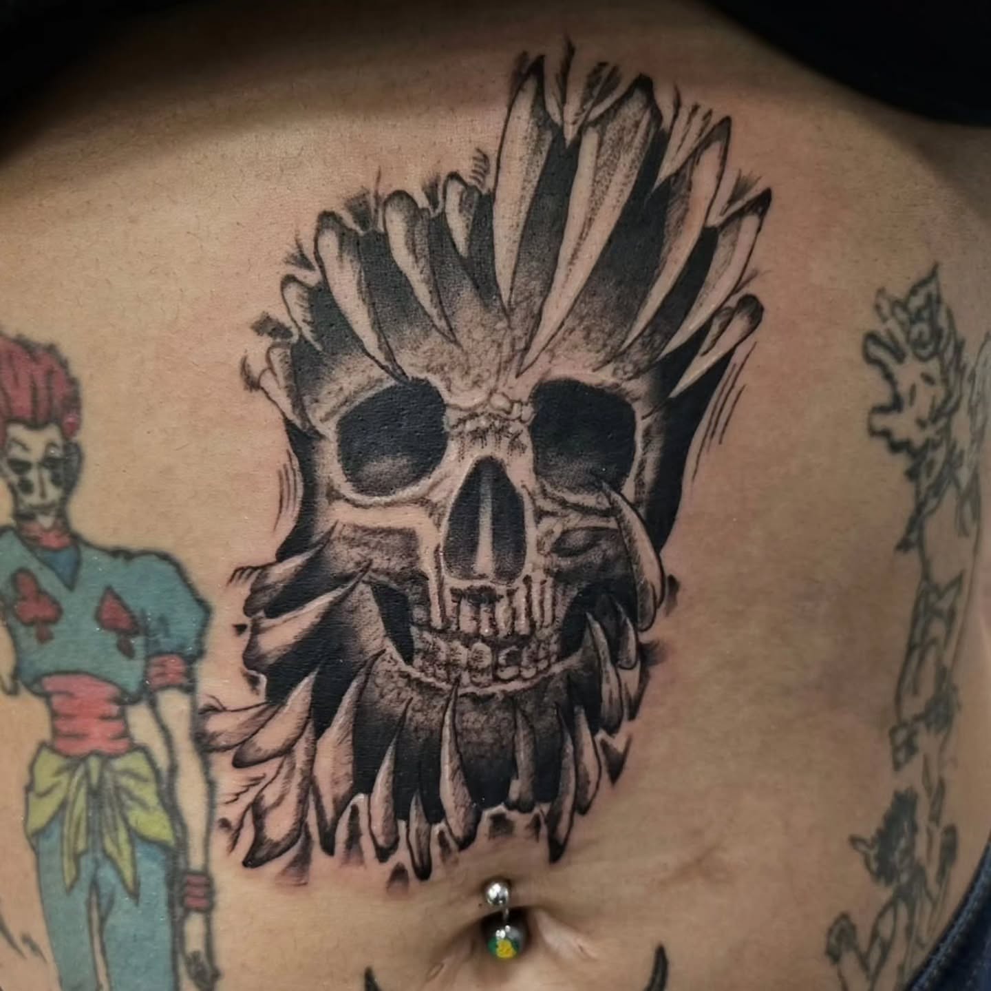 Skull with feathers black and grey tattoo on the torso by 𝕸 𝖆 𝖓 𝖔 𝖑 𝖔