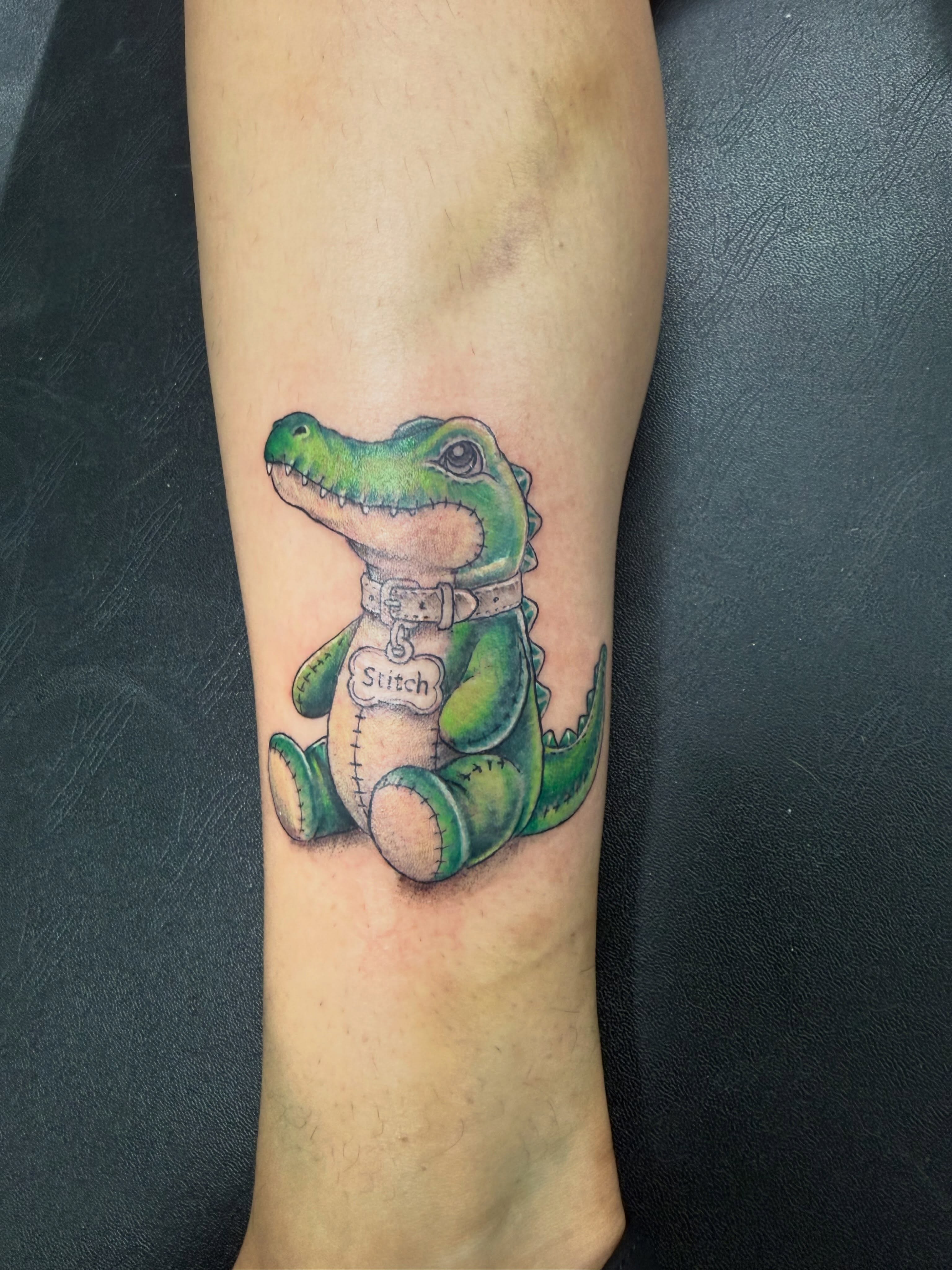 Stuffed crocodile realism tattoo on the forearm by Daniel Smith