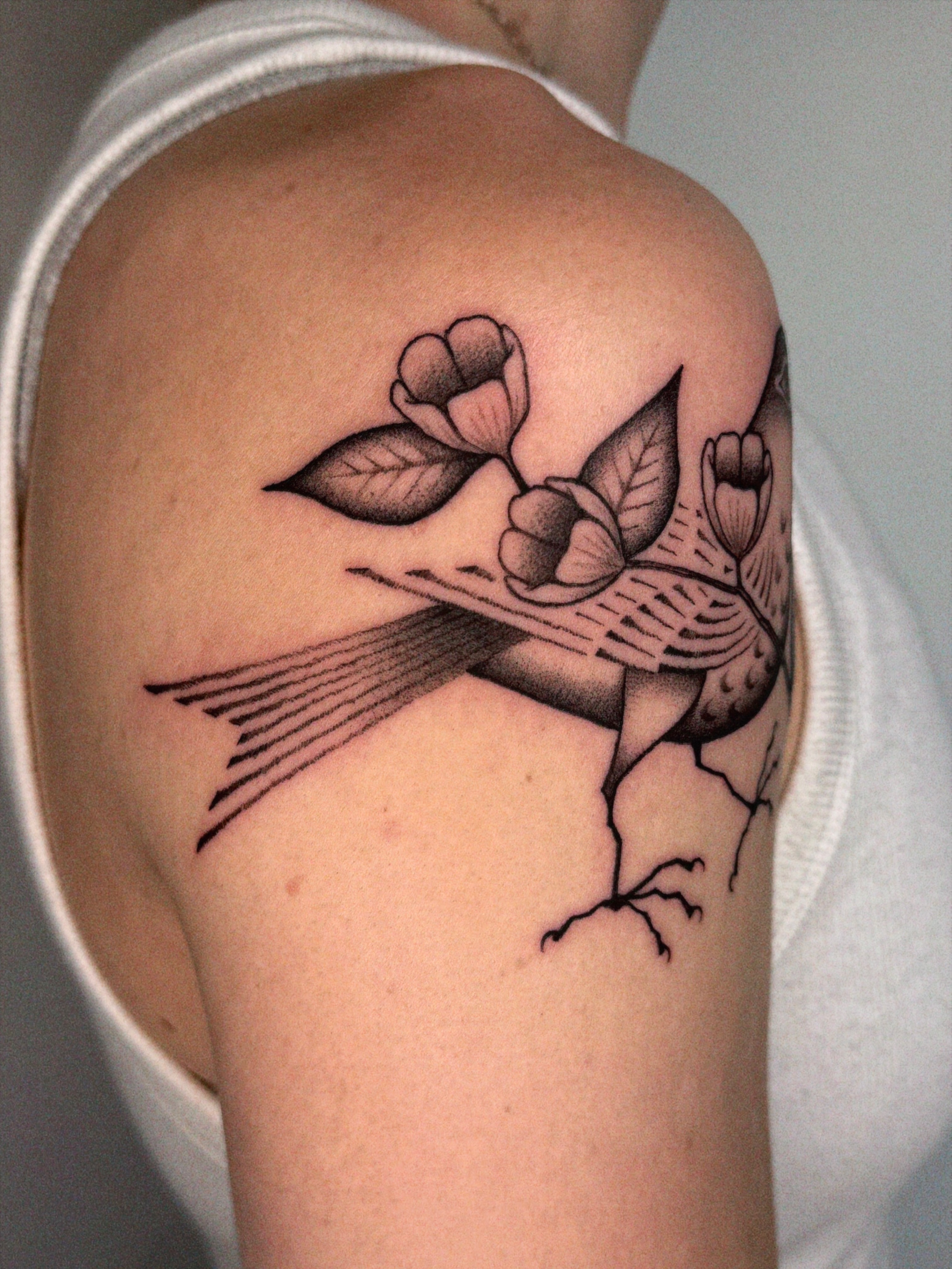 Bird with flowers black and grey tattoo on the shoulder by @inkshame