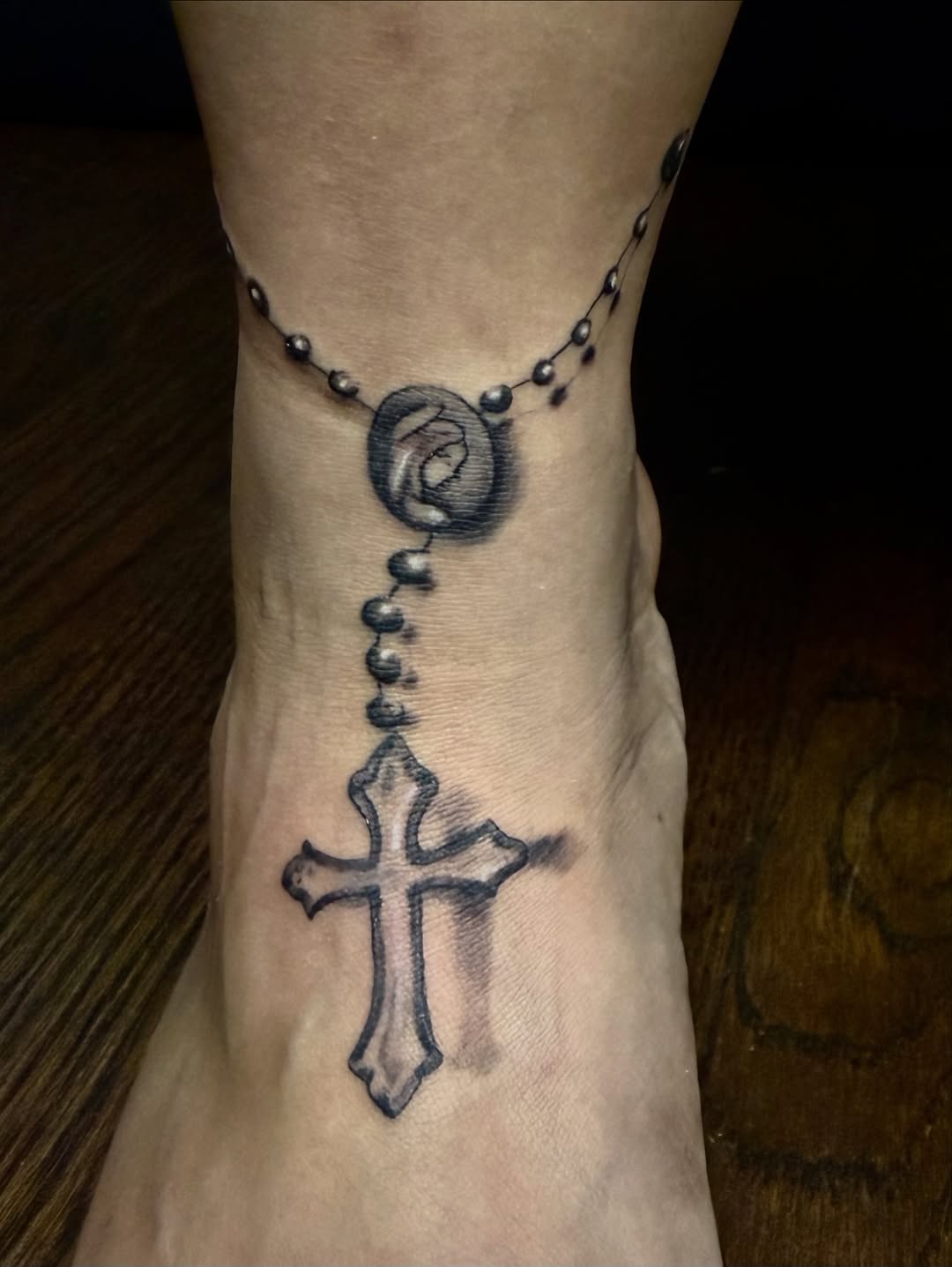 Rosary beads with cross and medallion fine line tattoo on the foot by Alexander Haber