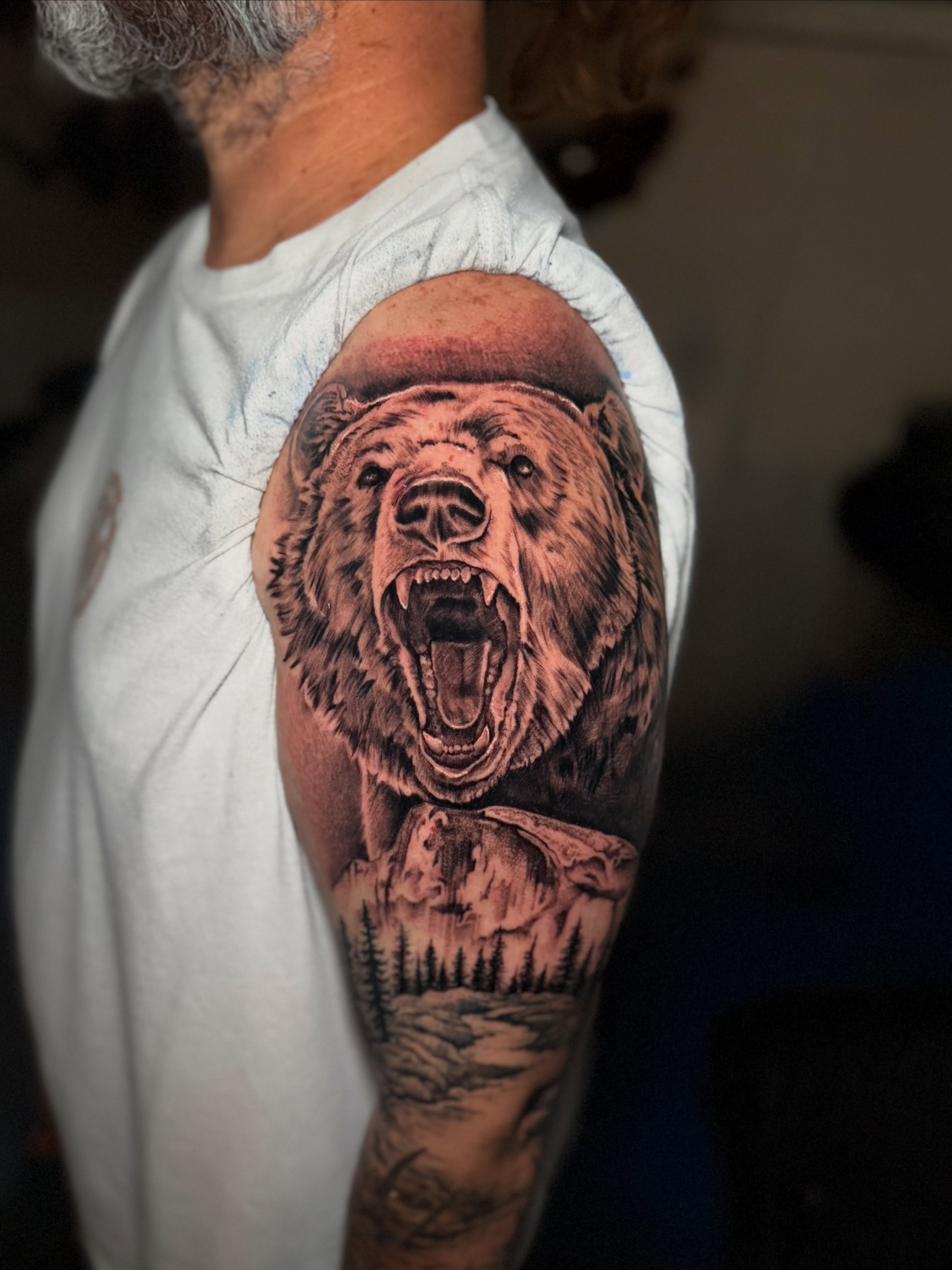 Roaring bear realism tattoo on the upper arm by Adam Newton