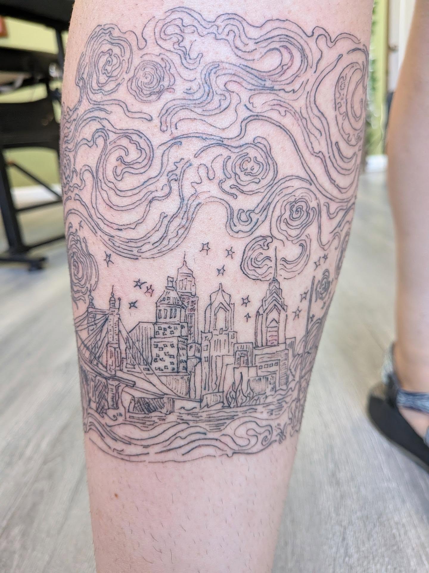 Cityscape black and grey tattoo on the leg by Ryan
