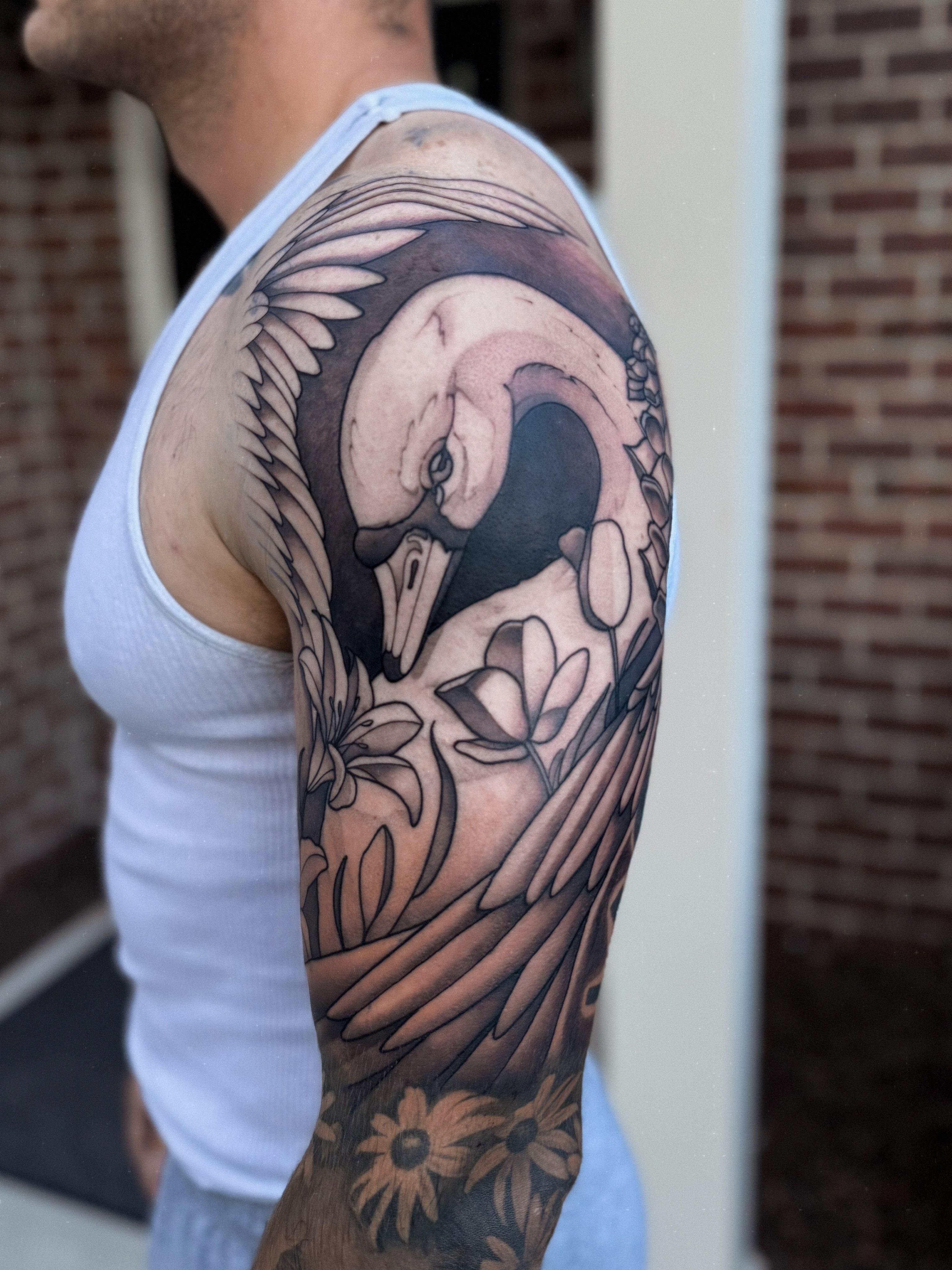 Swan and flowers realism tattoo on the upper arm by 𝔍𝔞𝔯𝔢𝔡 𝔞𝔩𝔩𝔢𝔫