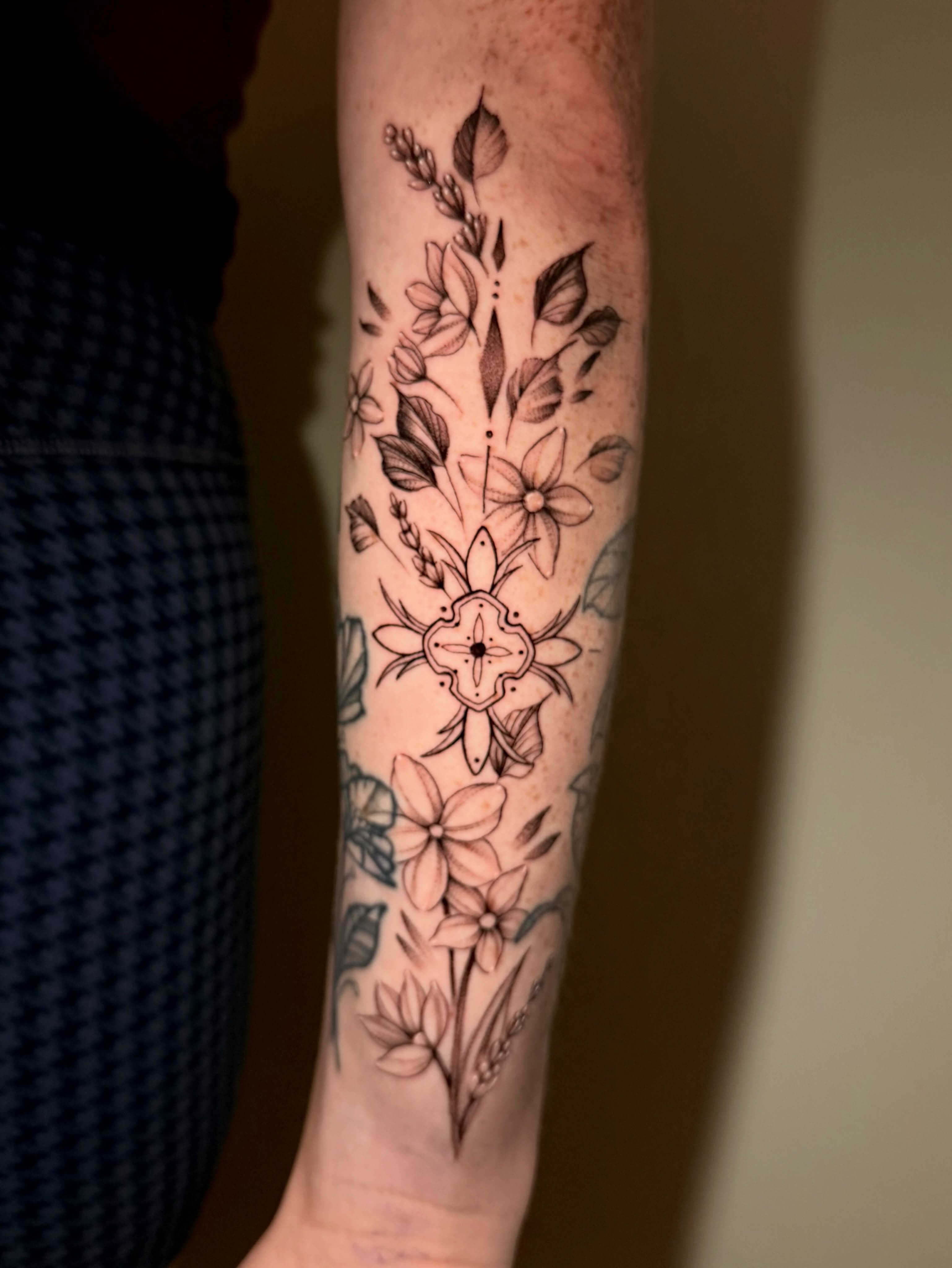 Floral bouquet black and grey tattoo on the forearm by Jacob Sass