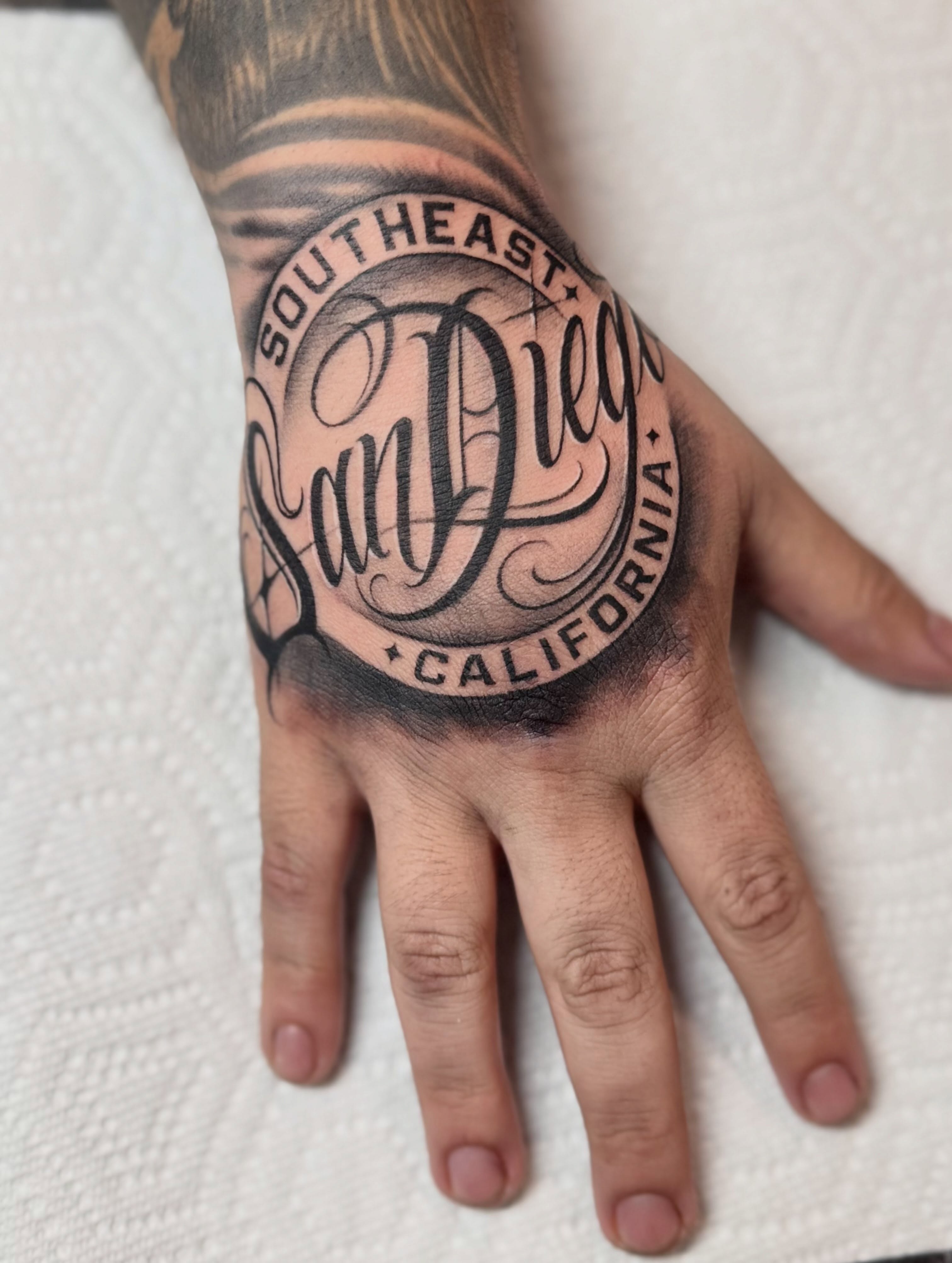 Southeast San Diego California lettering script tattoo on the hand by 𝕾𝖈𝖗𝖎𝖕𝖙 𝕾𝖕𝖊𝖈𝖎𝖆𝖑𝖎𝖘𝖙