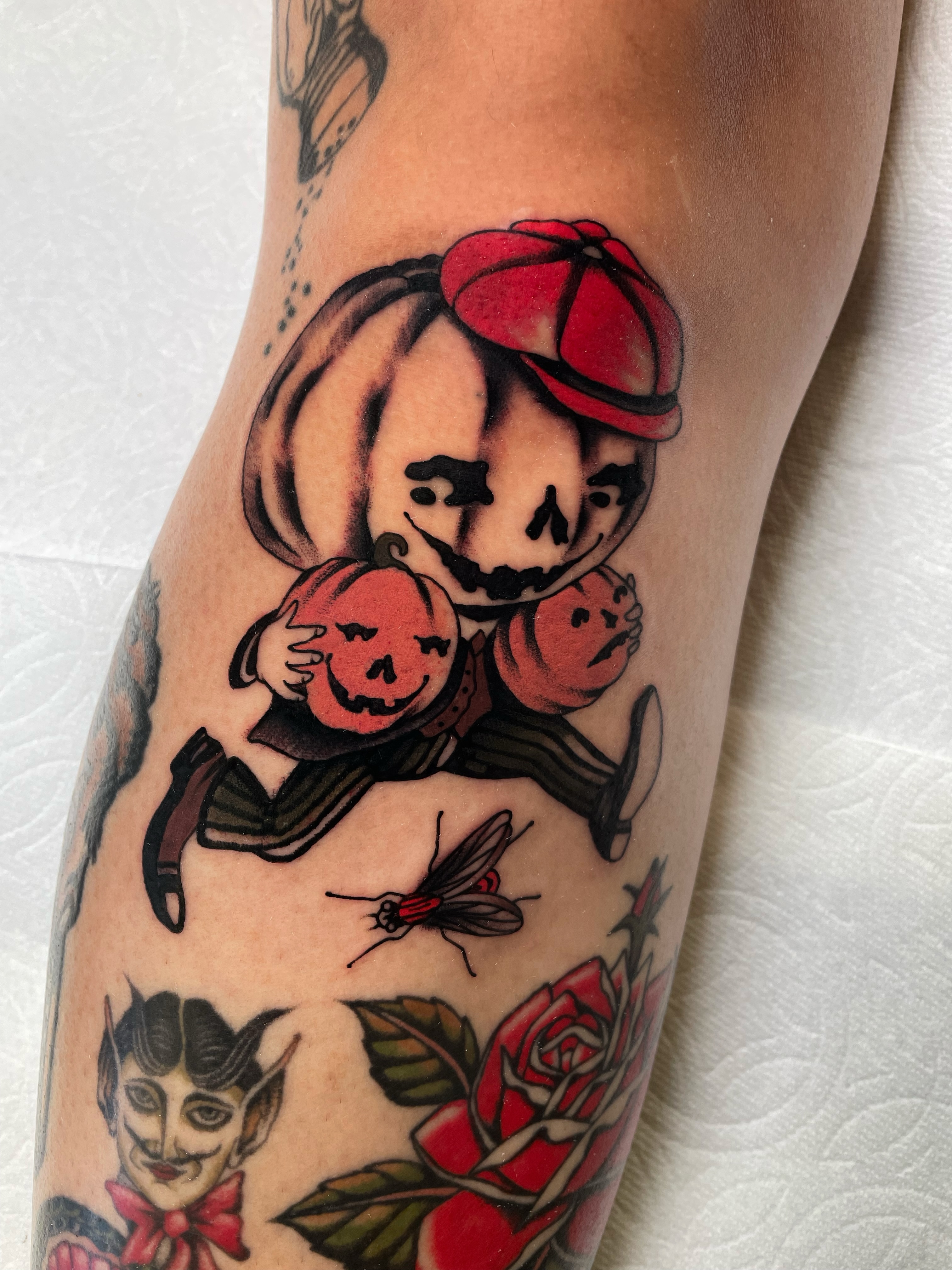Pumpkin-headed character American traditional tattoo on the forearm by Niko Mulhearn