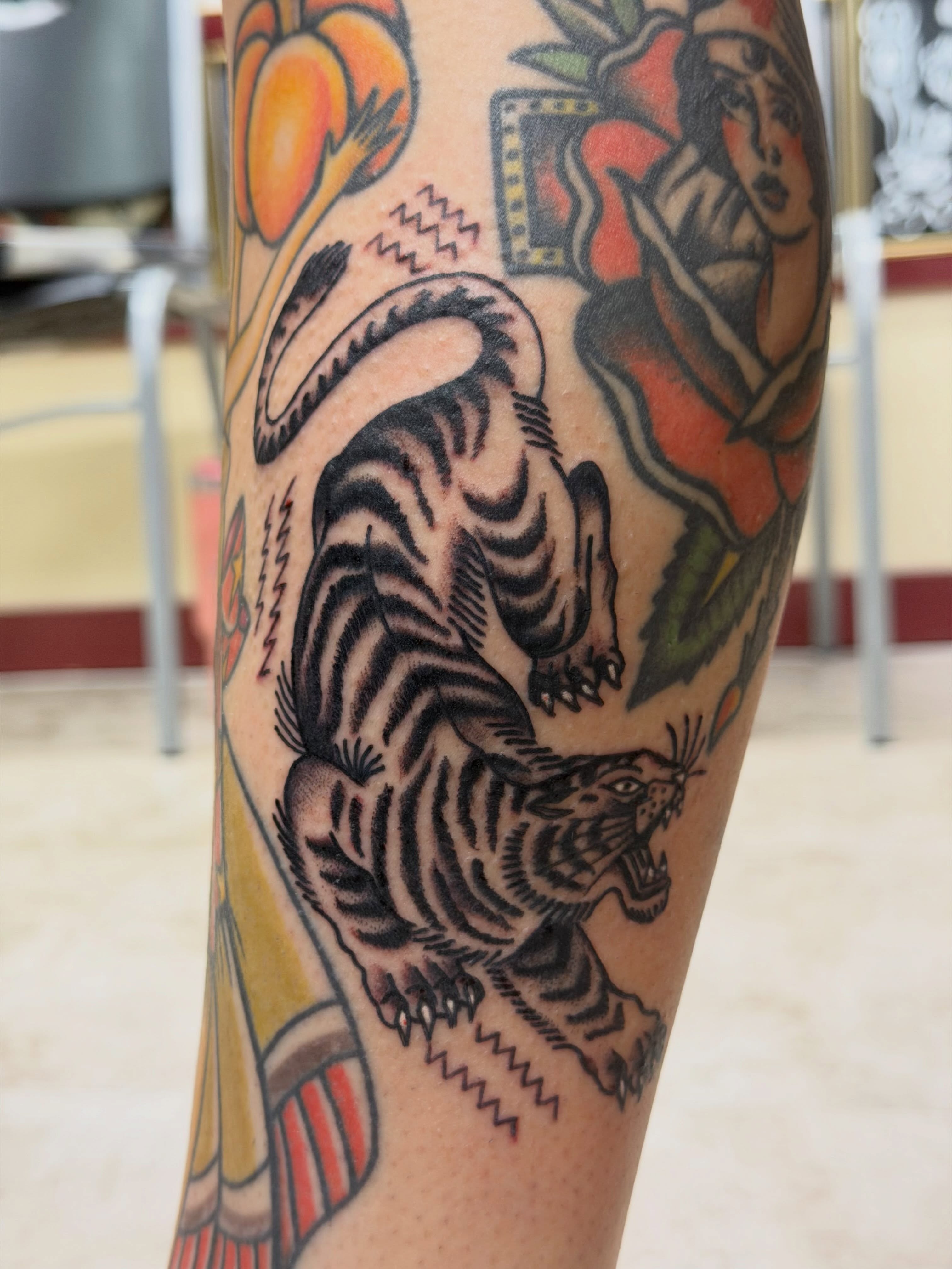 Tiger and woman American traditional tattoo on the forearm by Gerald Bellmore