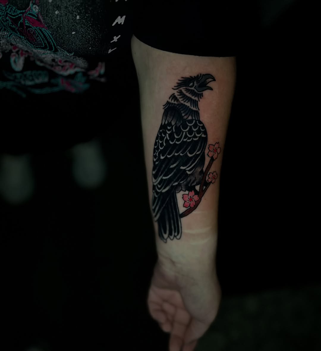 Crow and cherry blossoms black and grey tattoo on the forearm by Mason McCubbin
