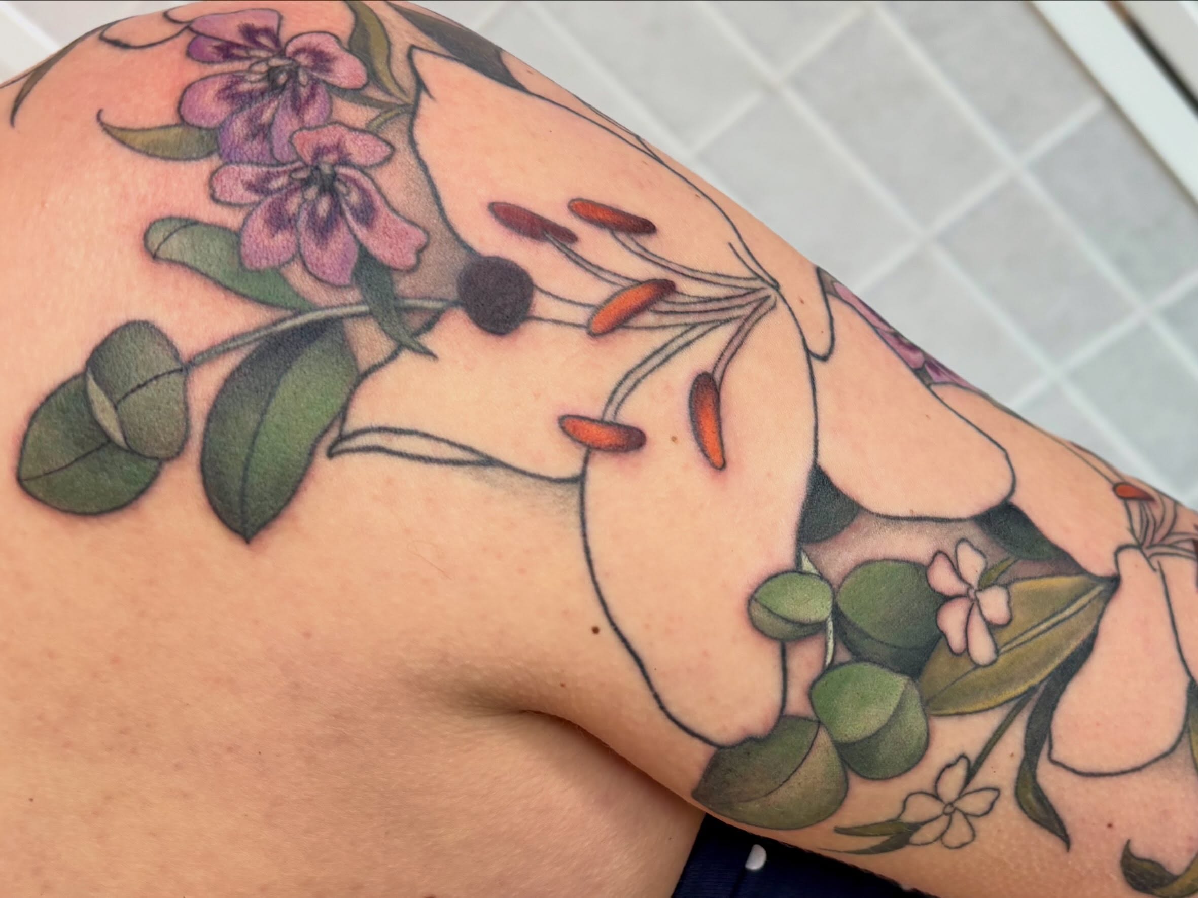 Floral arrangement realism tattoo on the shoulder by Leah Leinani