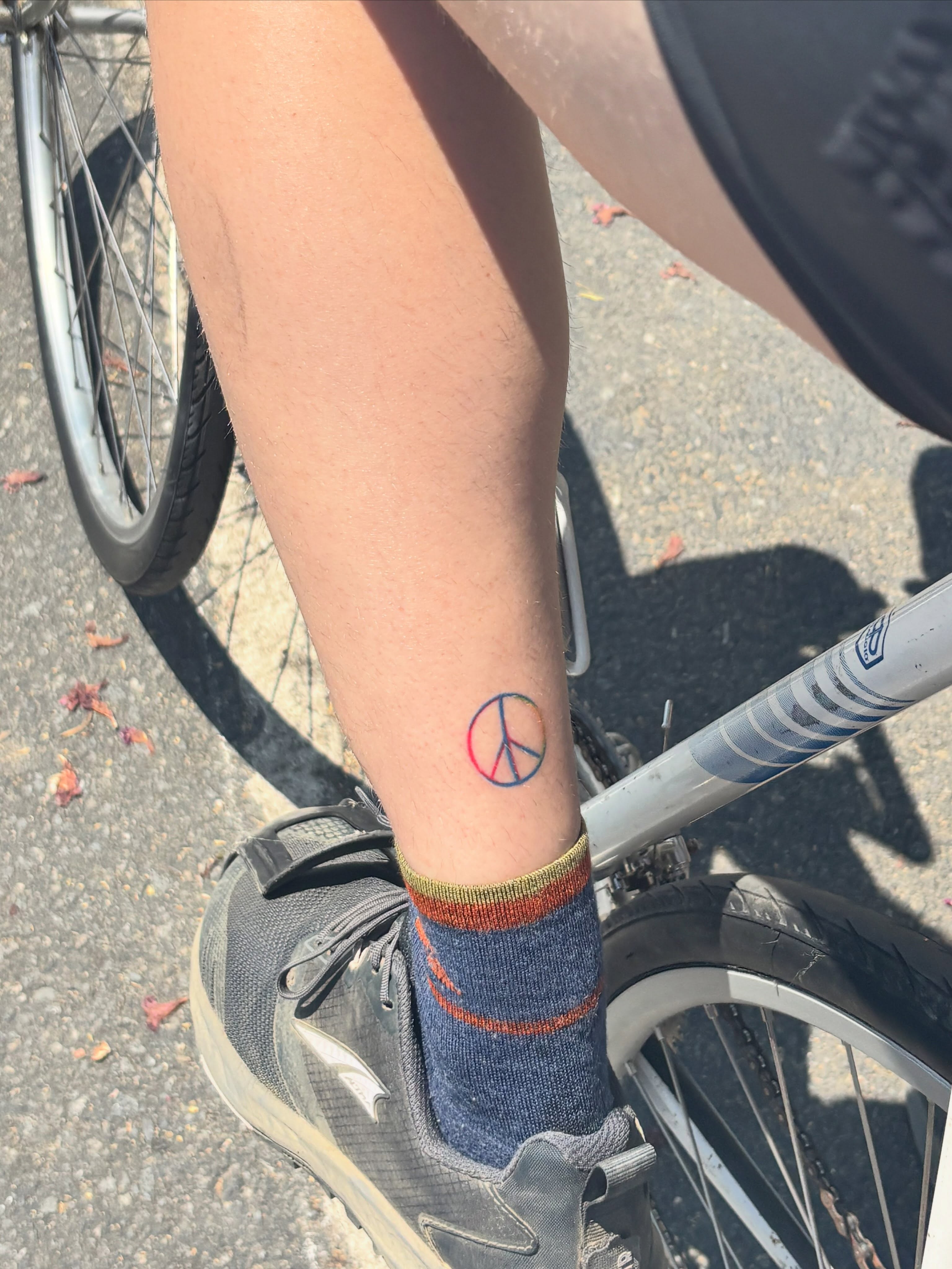 Peace symbol dotwork tattoo on the calf by Nicolette