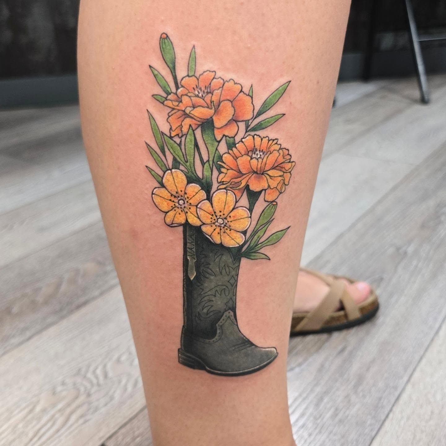 Cowboy boot with flowers realism tattoo on the calf by Britty Love, Nashville, Tennessee