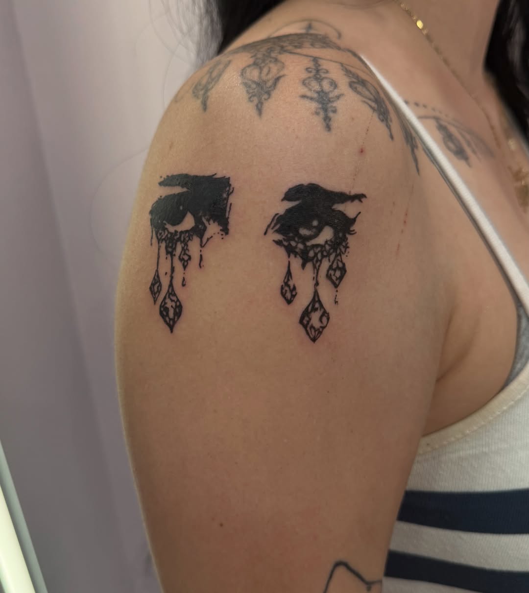 Tears black and grey tattoo on the shoulder by Lindsey
