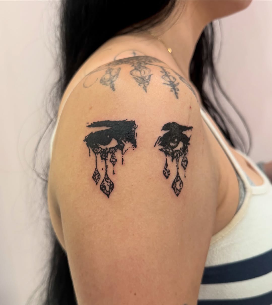 Tears black and grey tattoo on the shoulder by Lindsey