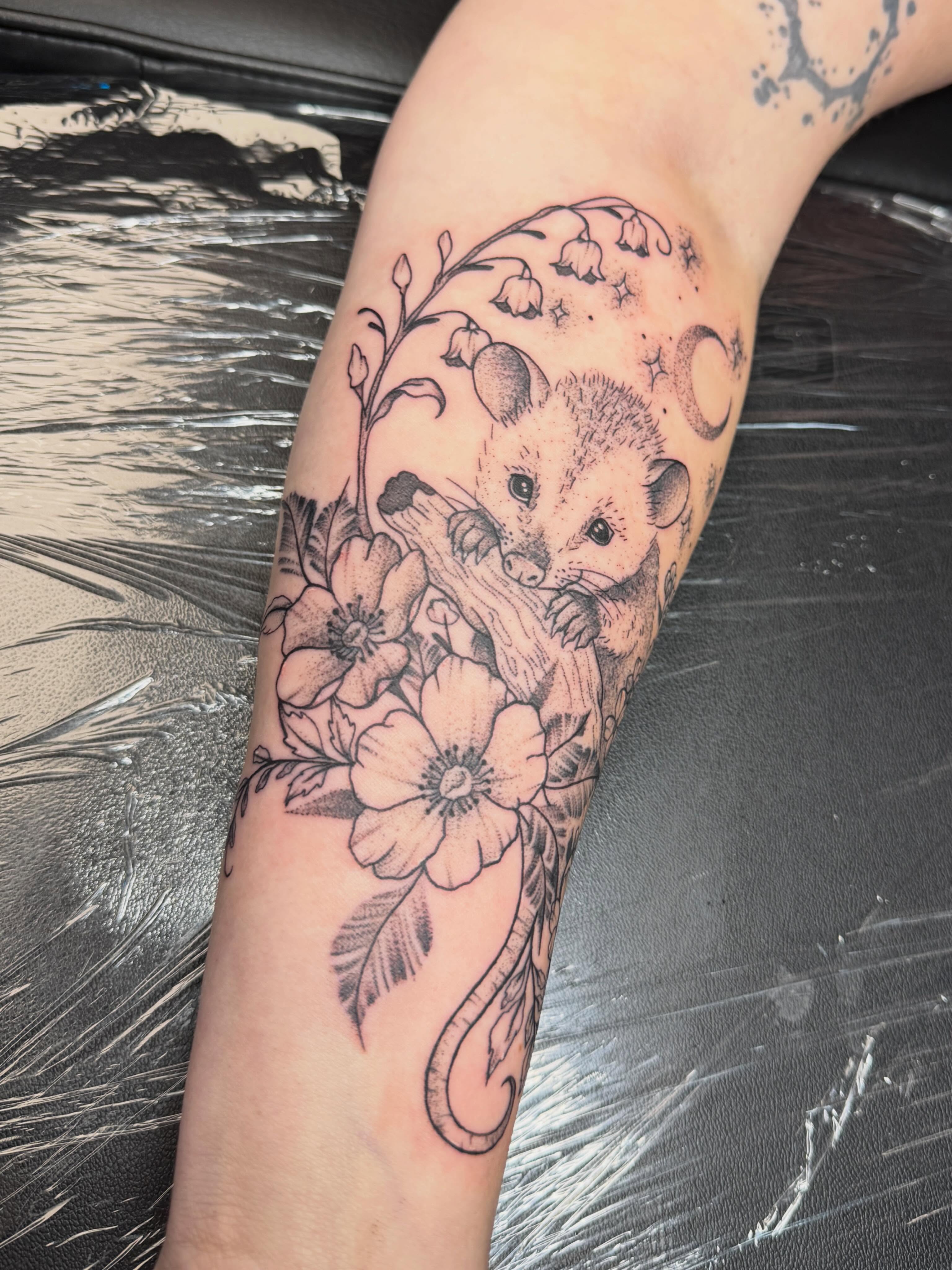 Possum and flowers black and grey tattoo on the forearm by Abby