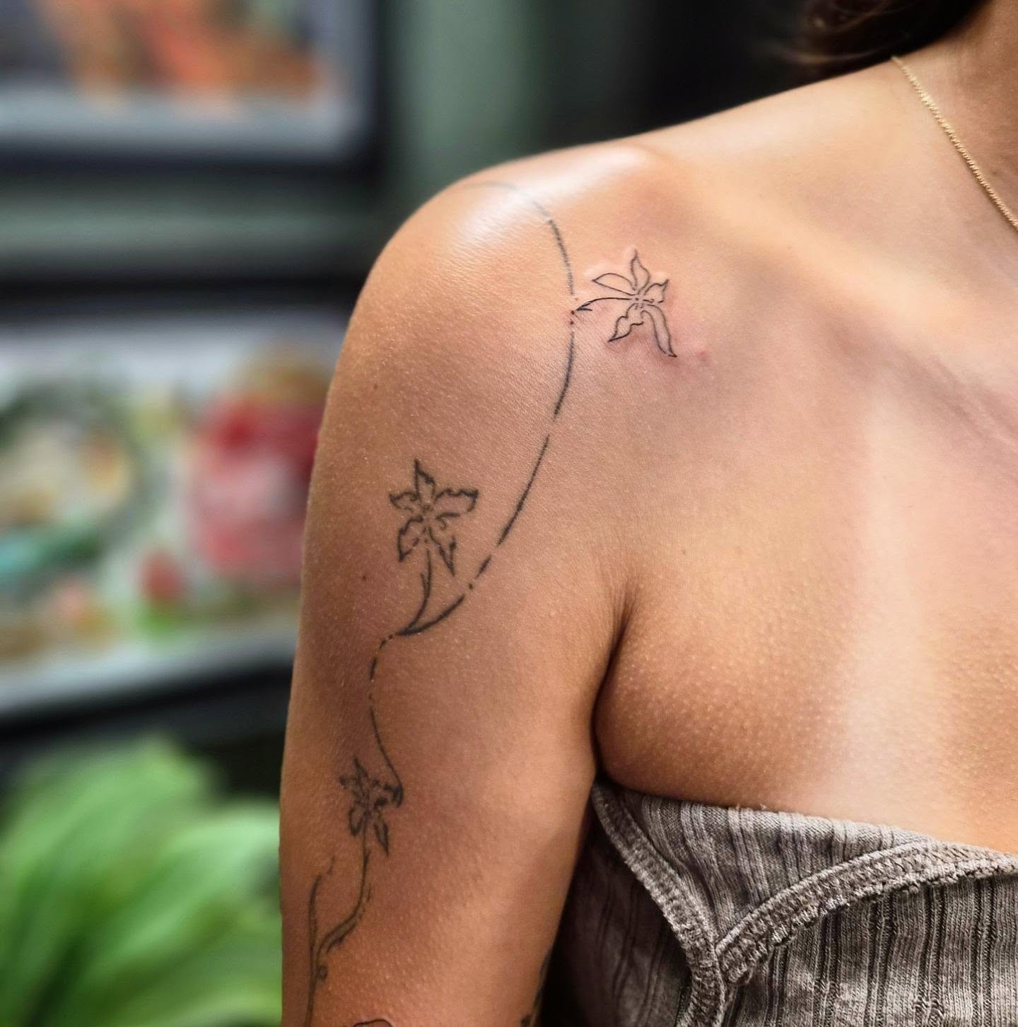Flower vine fine line tattoo on the shoulder by Teresa Rose Tattoos