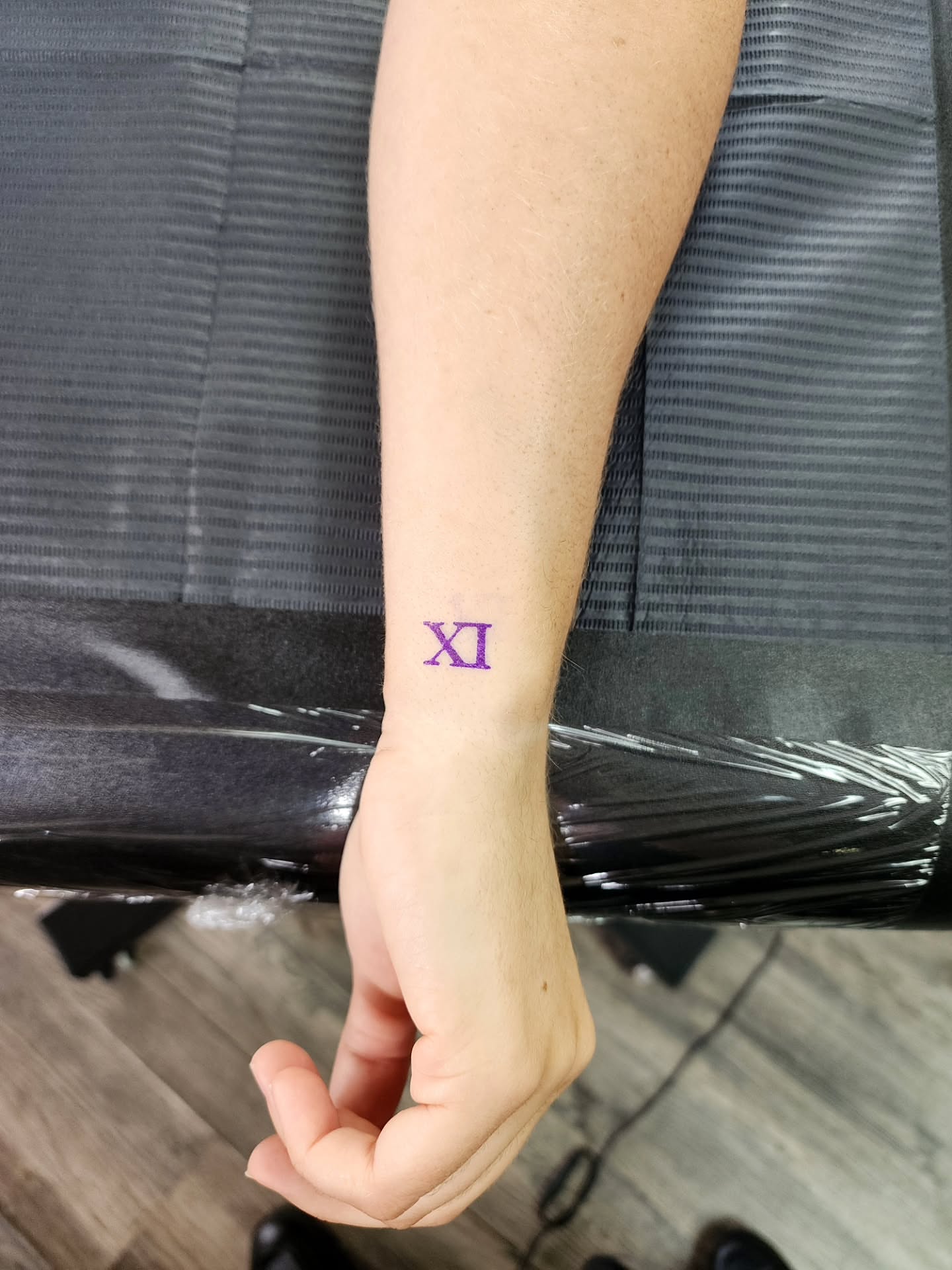 Roman numeral xi lettering script tattoo on the forearm by Alex ▪︎ Tattoo Apprentice
